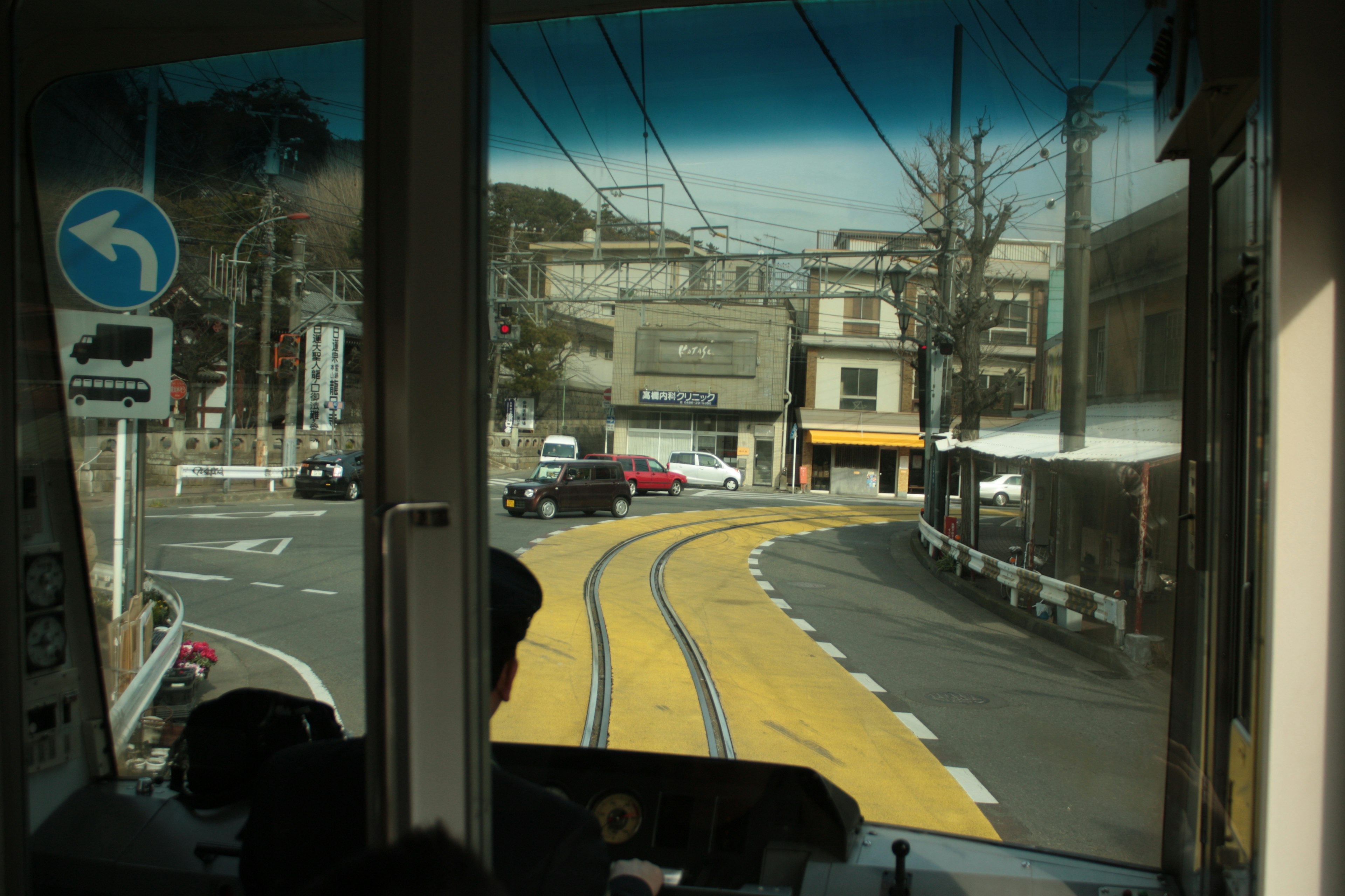 視点は路面電車の運転席からの景色でカーブする線路と周囲の建物が見える