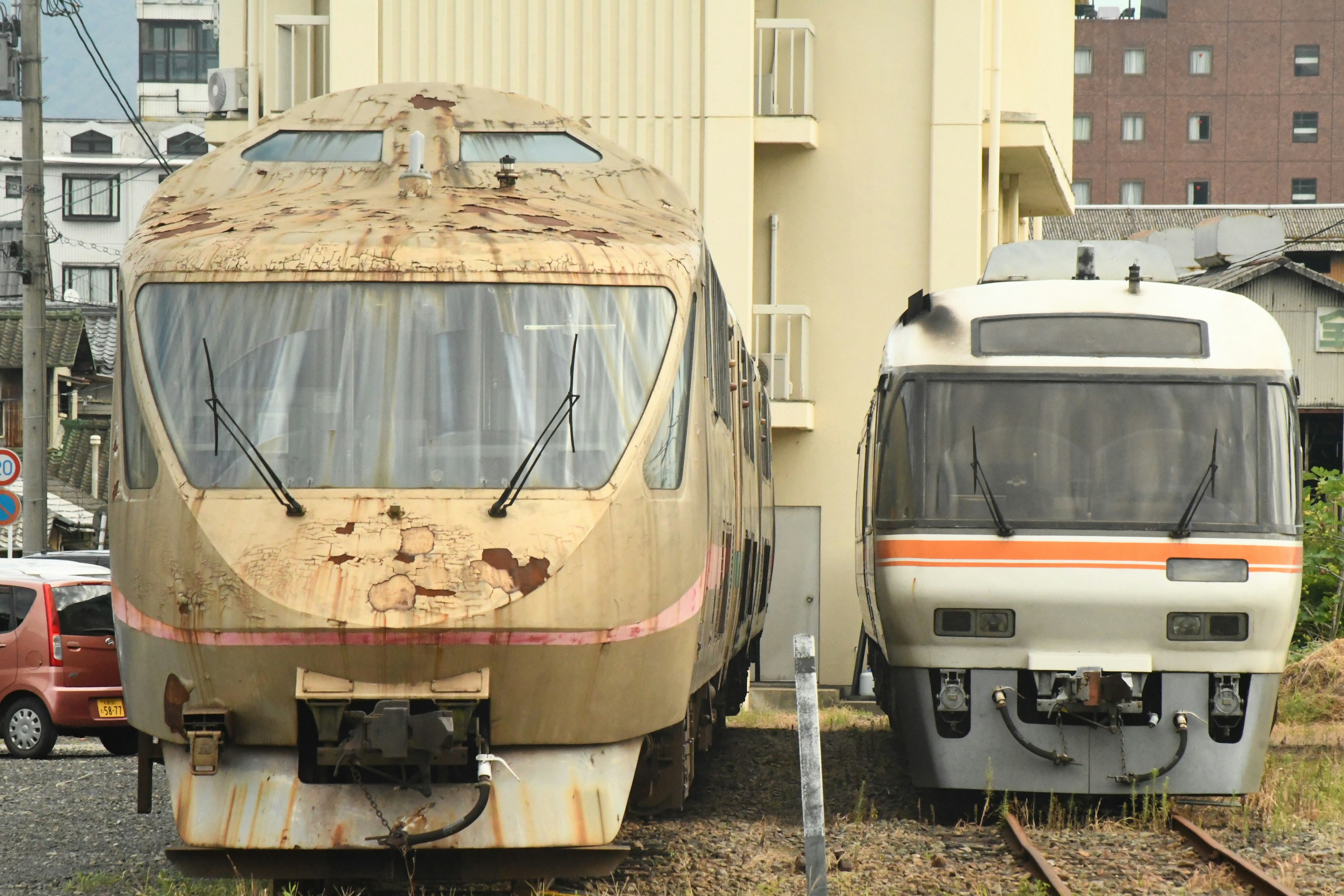 Ein alter rostiger Zug neben einem modernen Zug an einem Bahnhof