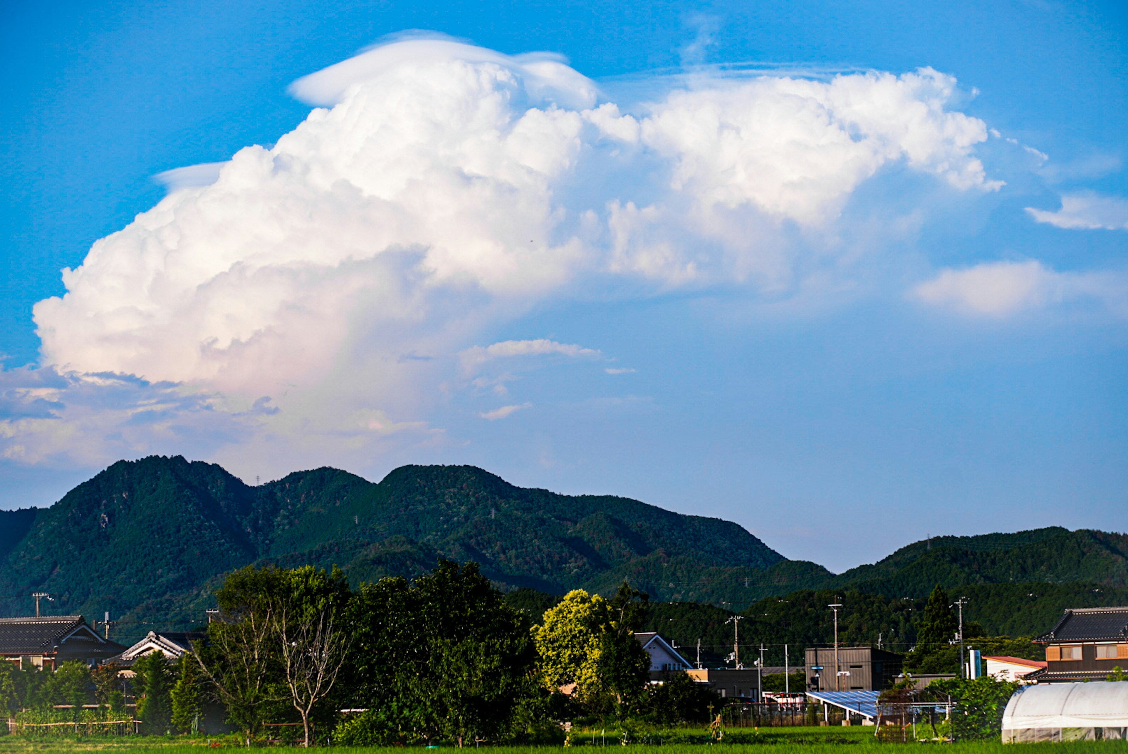 青空の下に広がる白い雲と山々の風景