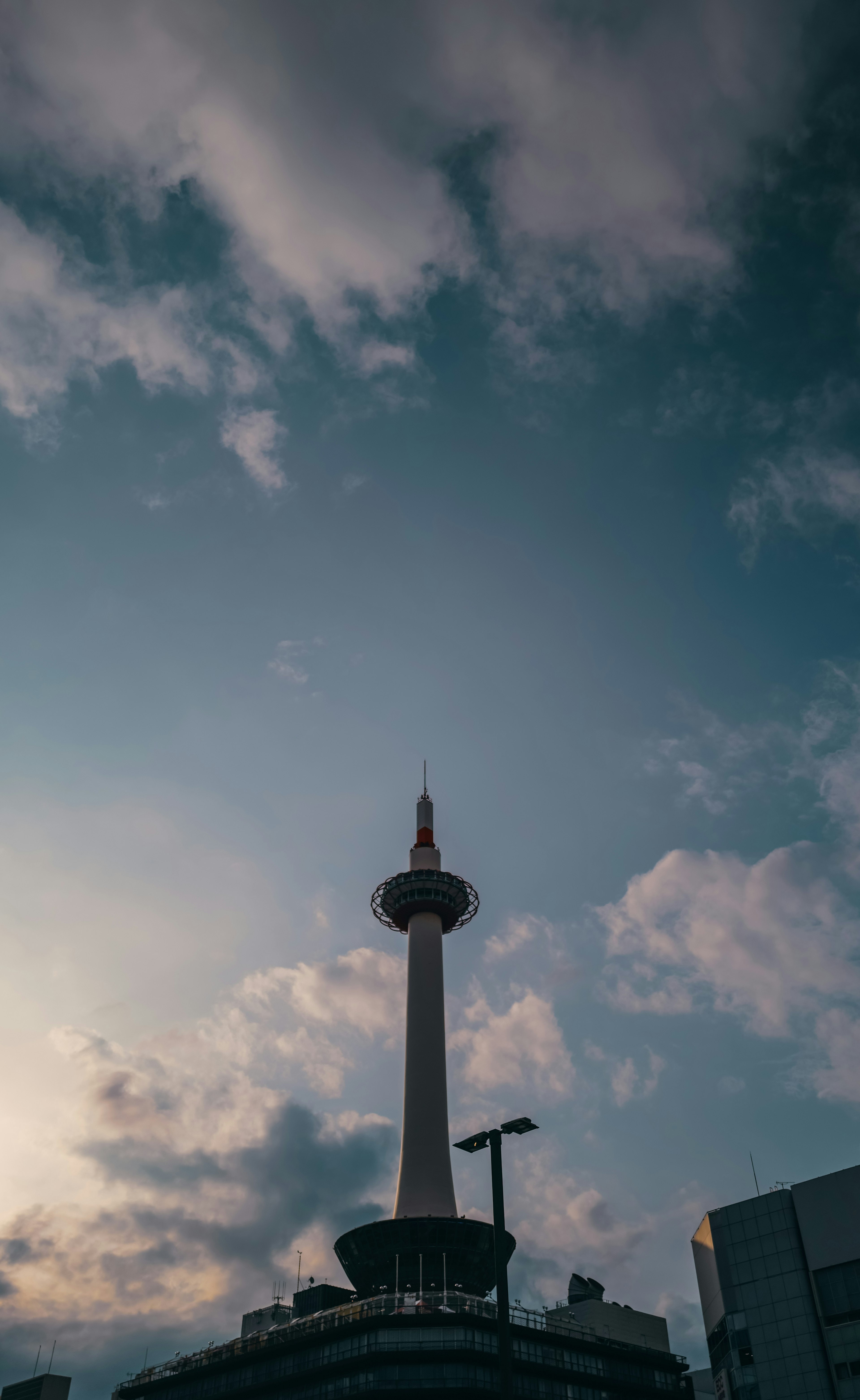 京都タワーが夕焼けの空にそびえるシルエット