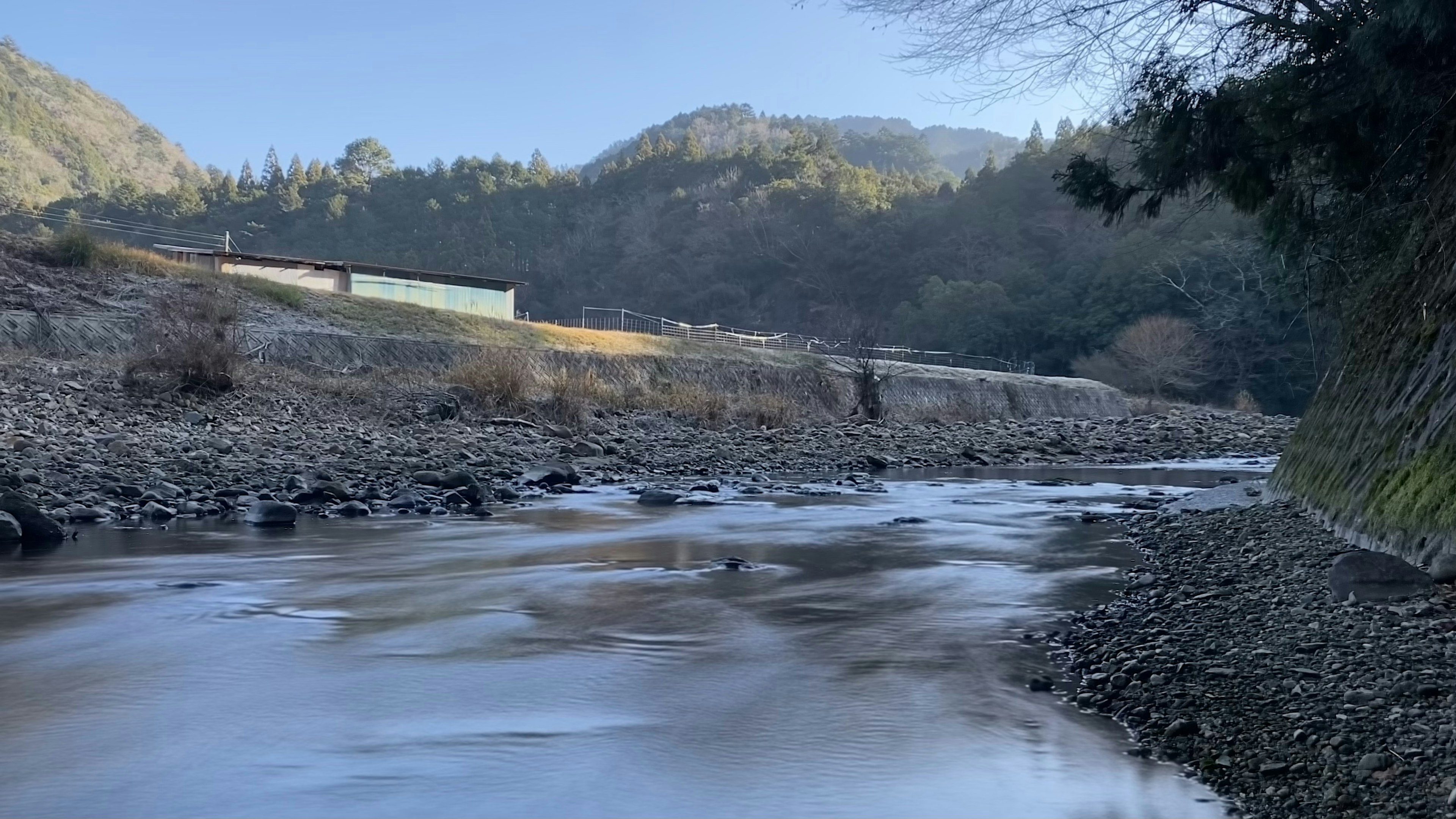 静かな川の流れと山の風景