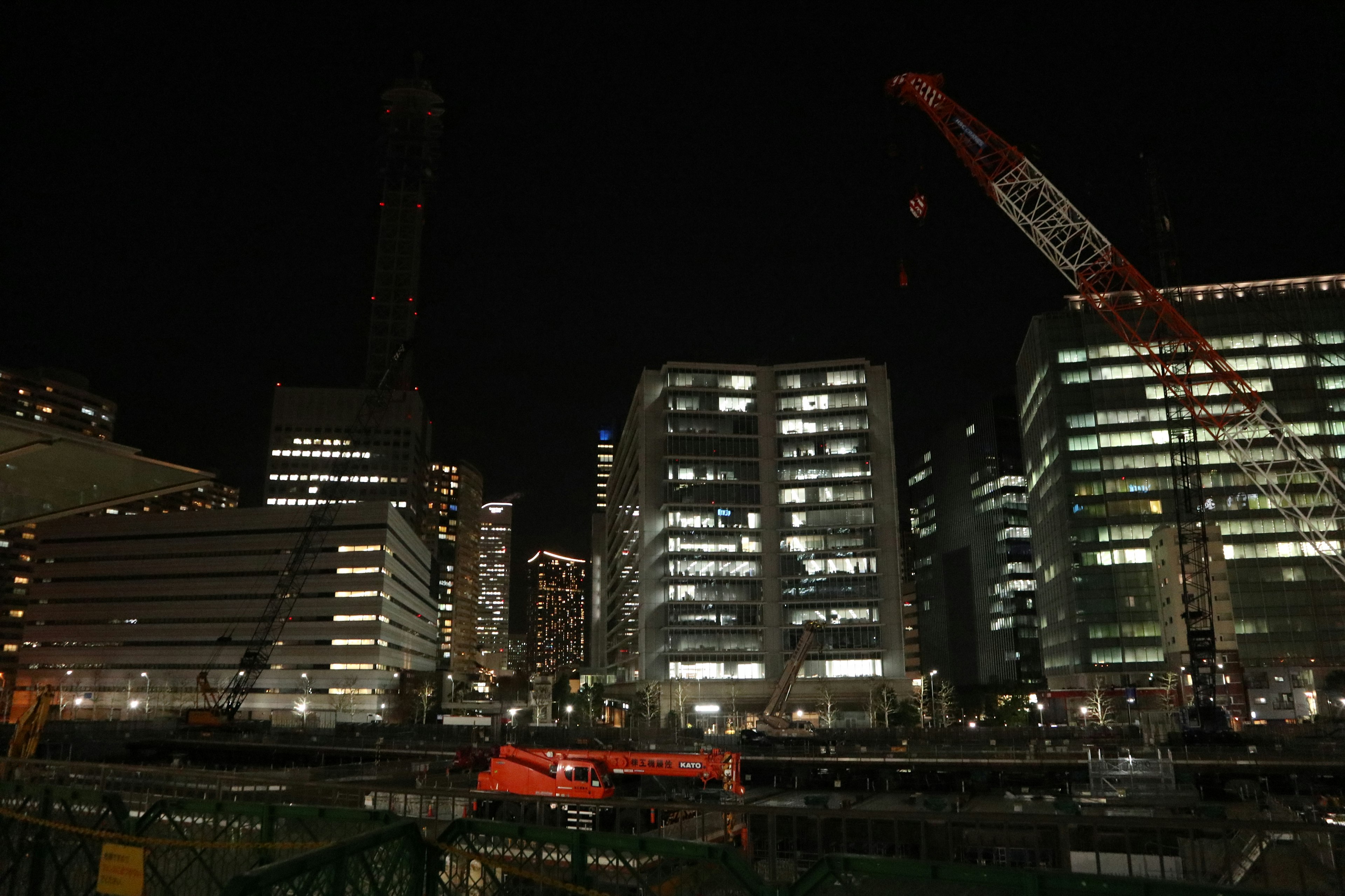 夜間城市景觀包含摩天大樓和起重機