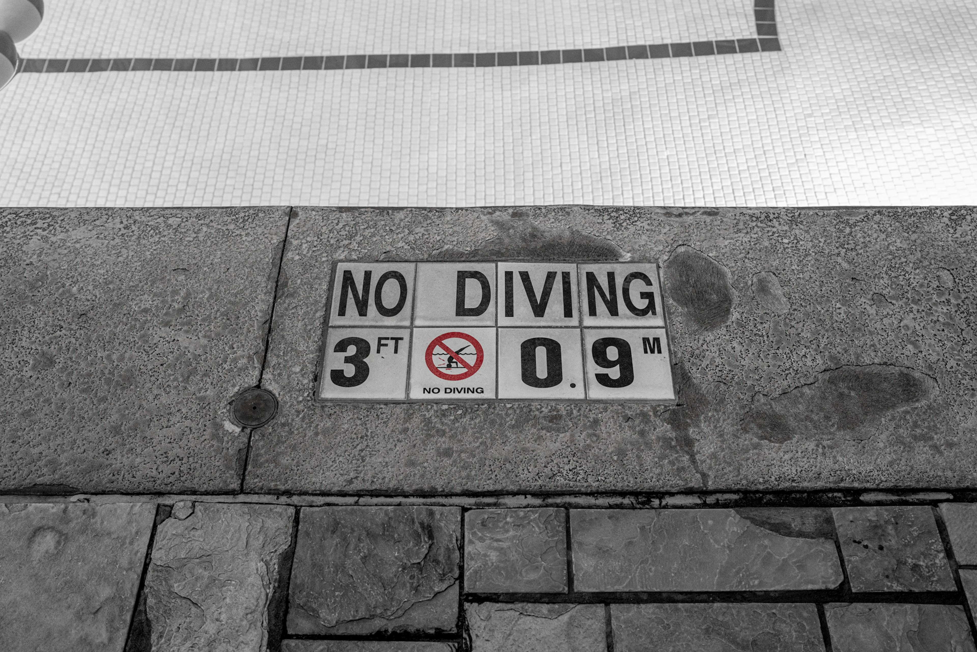 Sign indicating no diving at the pool with depth measurement