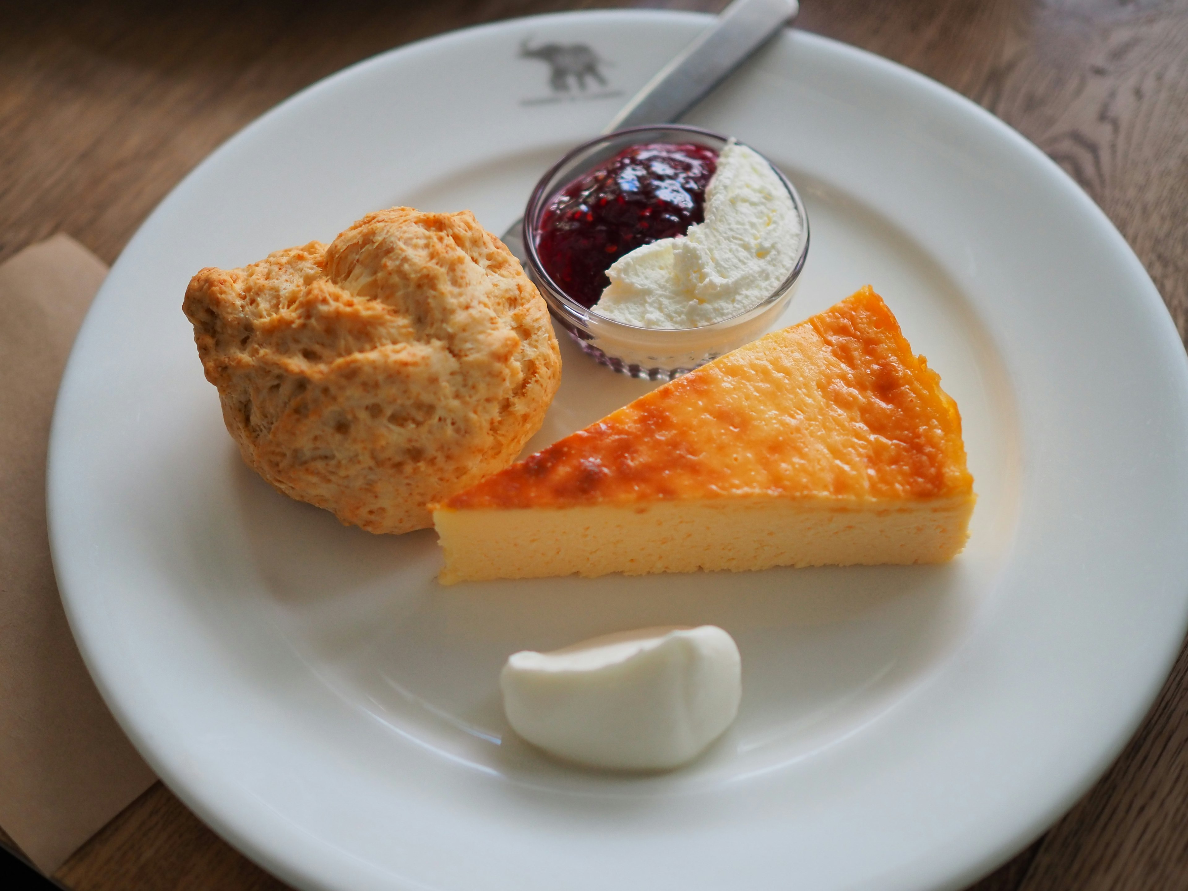 Dessert auf einem Teller mit Scone Sahne Marmelade und gebackenem Pudding