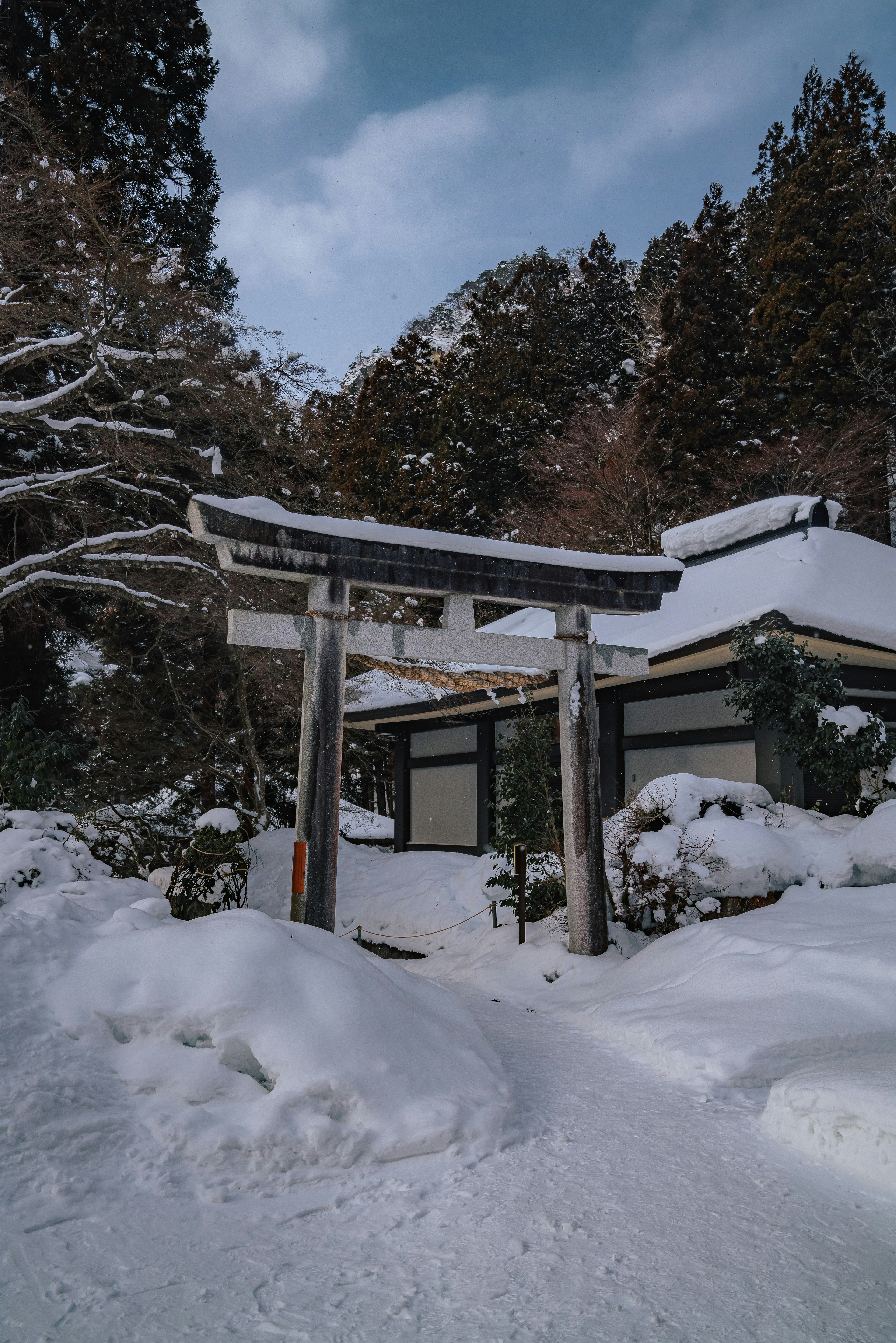 Puerta de santuario cubierta de nieve y edificios tradicionales en un paisaje sereno