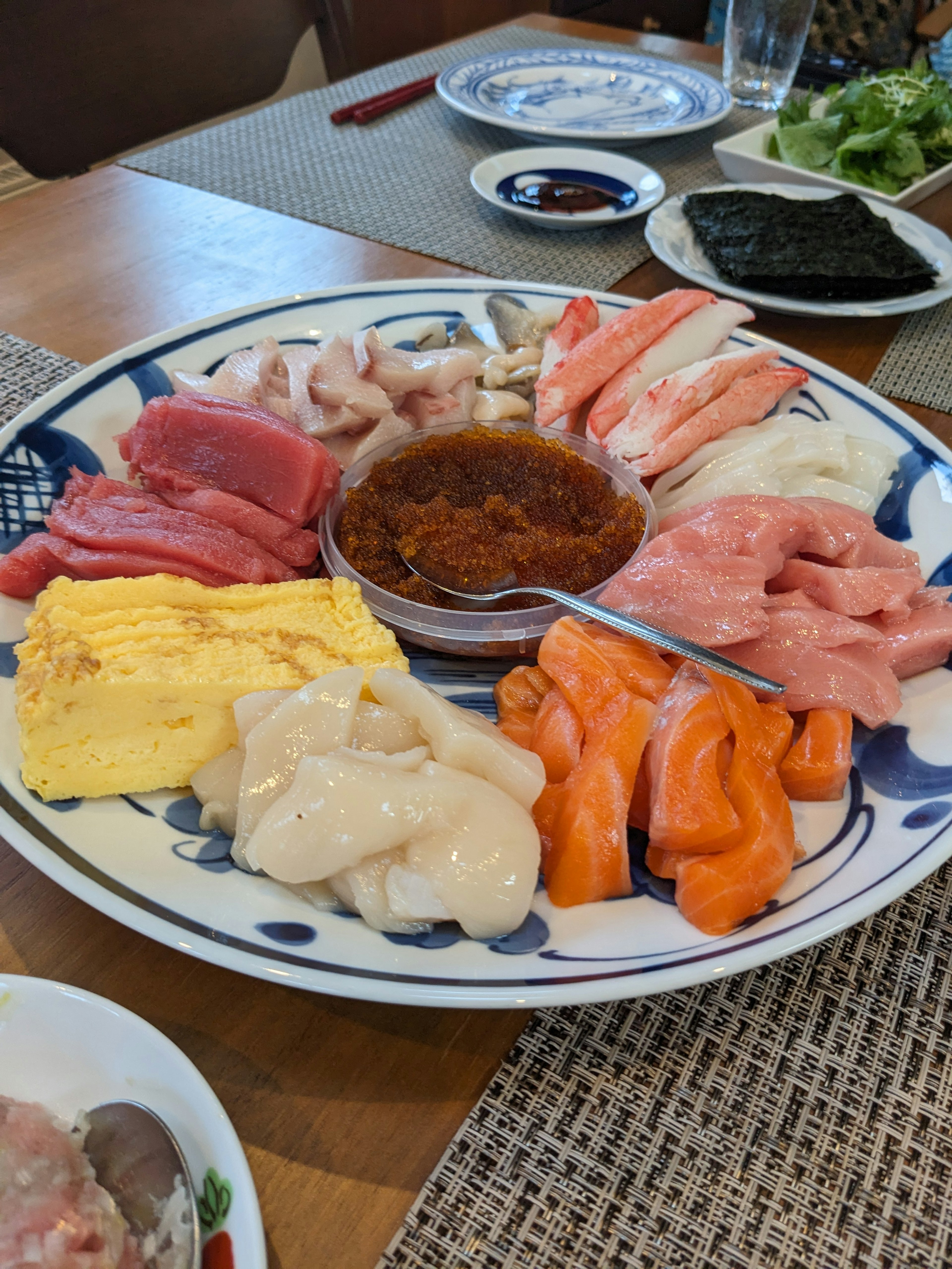 A colorful platter of sashimi and tamagoyaki with dipping sauce