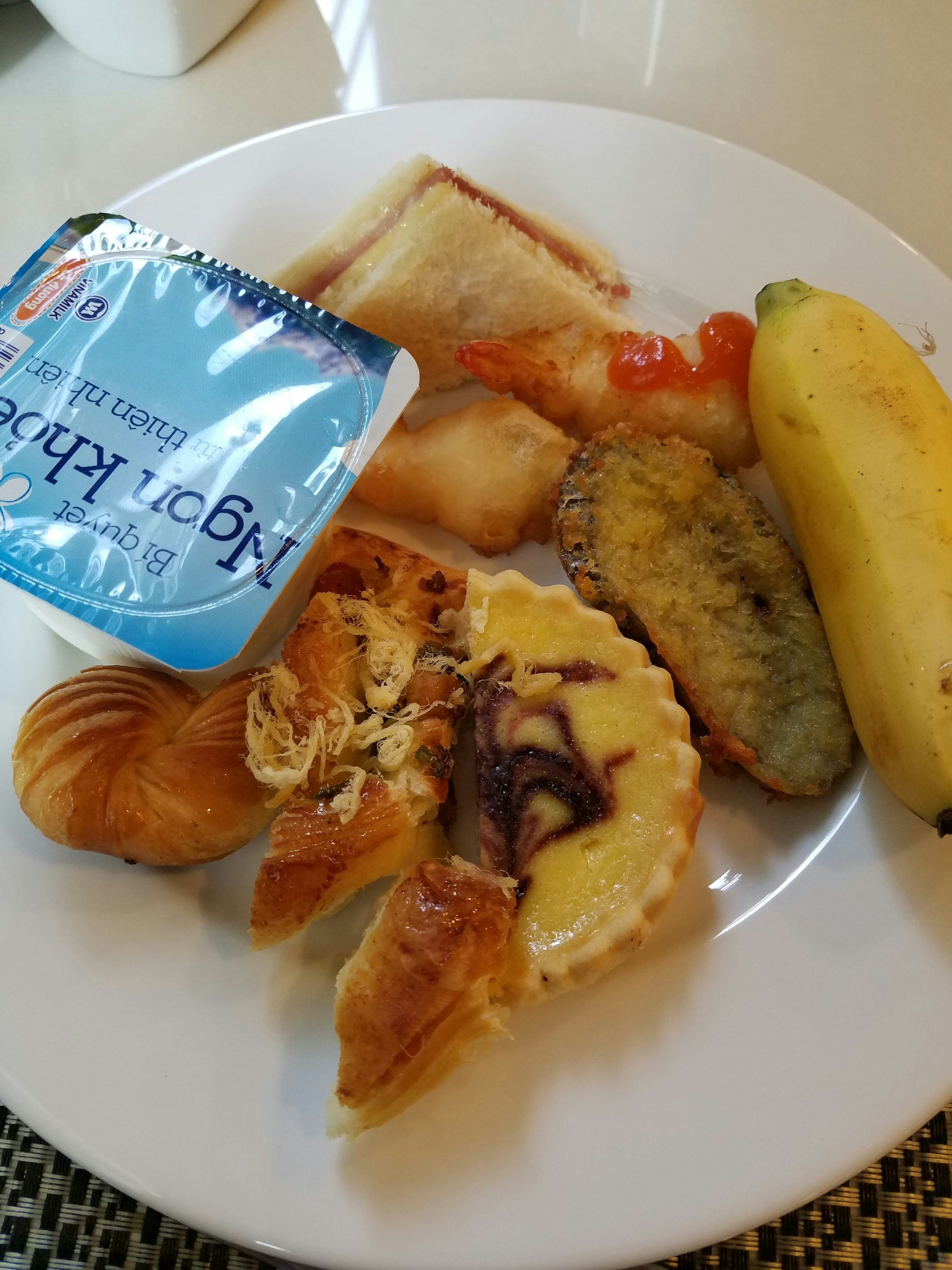 A plate featuring pastries, fruits, and yogurt