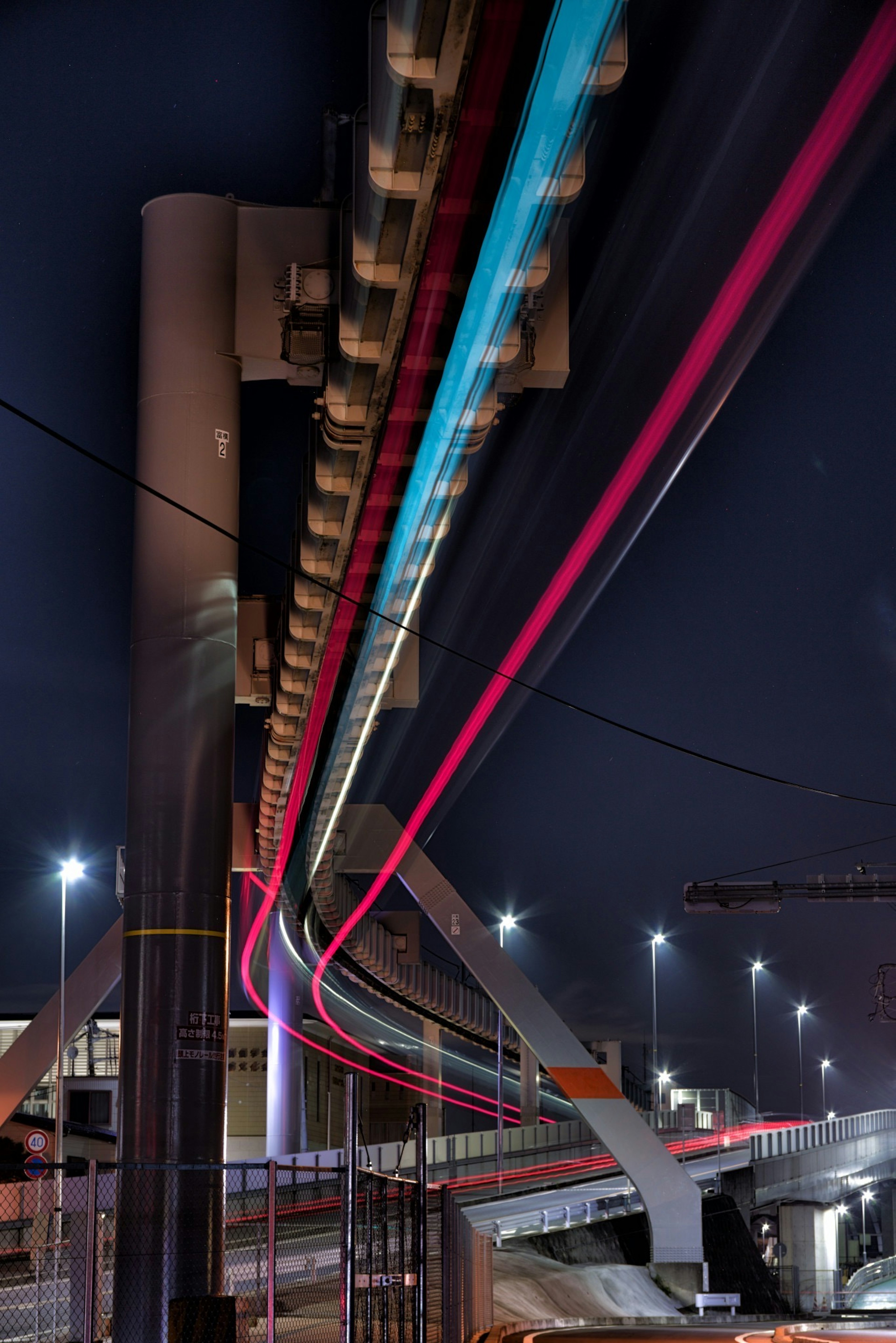 Acercamiento a las vías del monorraíl iluminadas por la noche en una ciudad