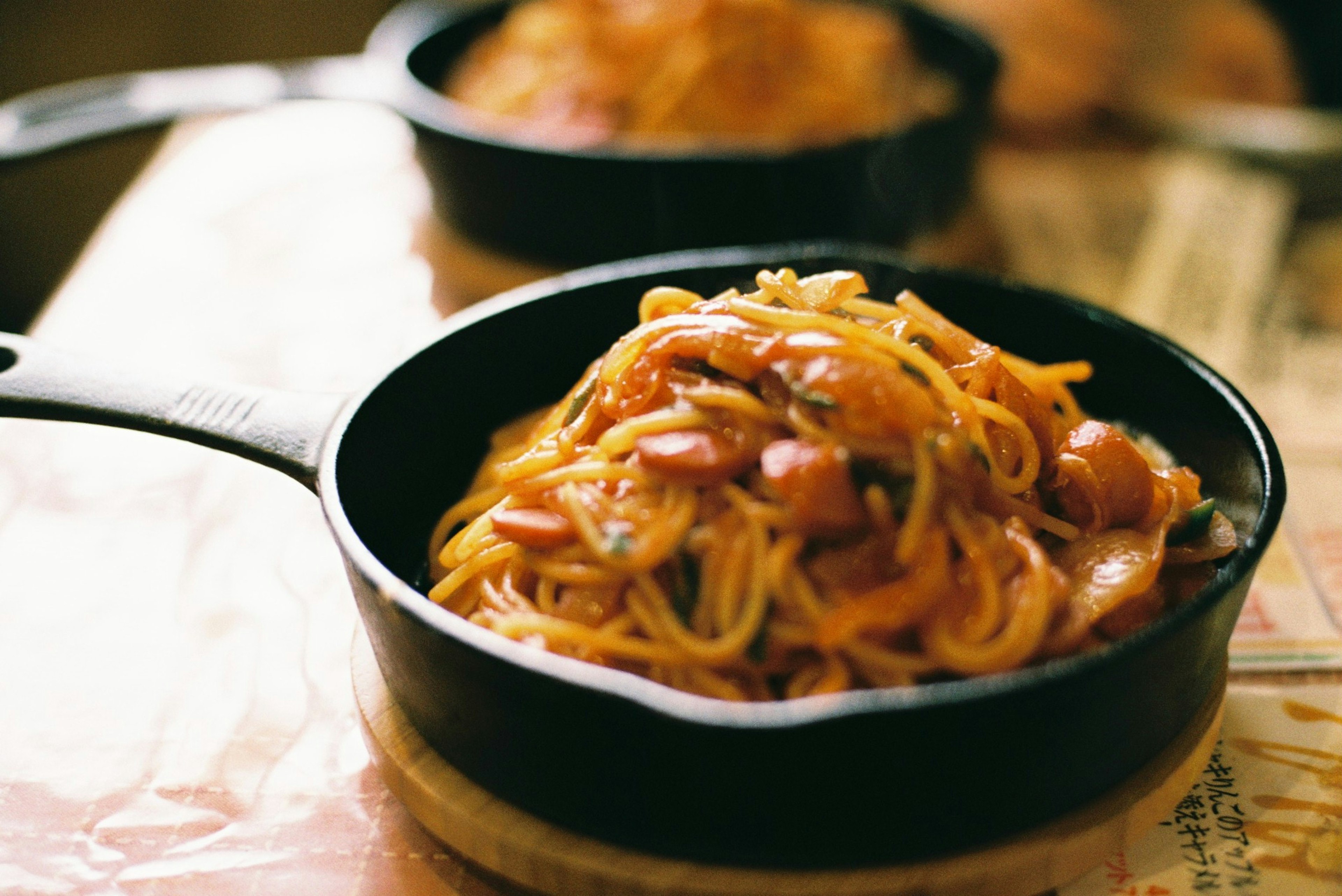 黒いスキレットに盛られたスパゲッティと豆の料理