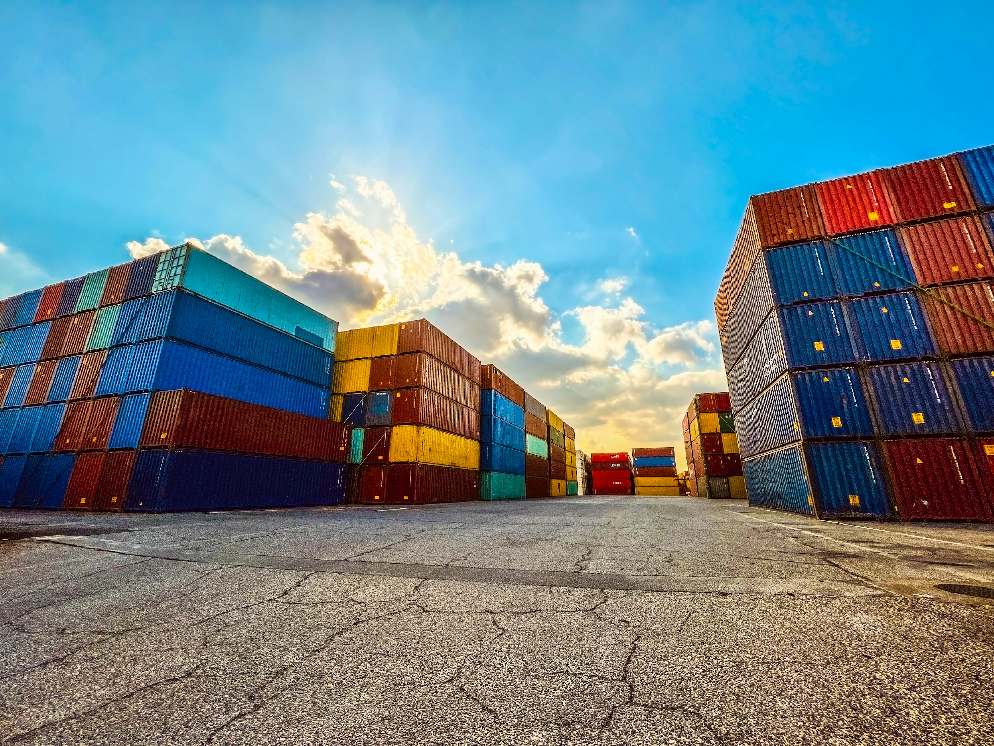 Colorful shipping containers stacked under a bright blue sky