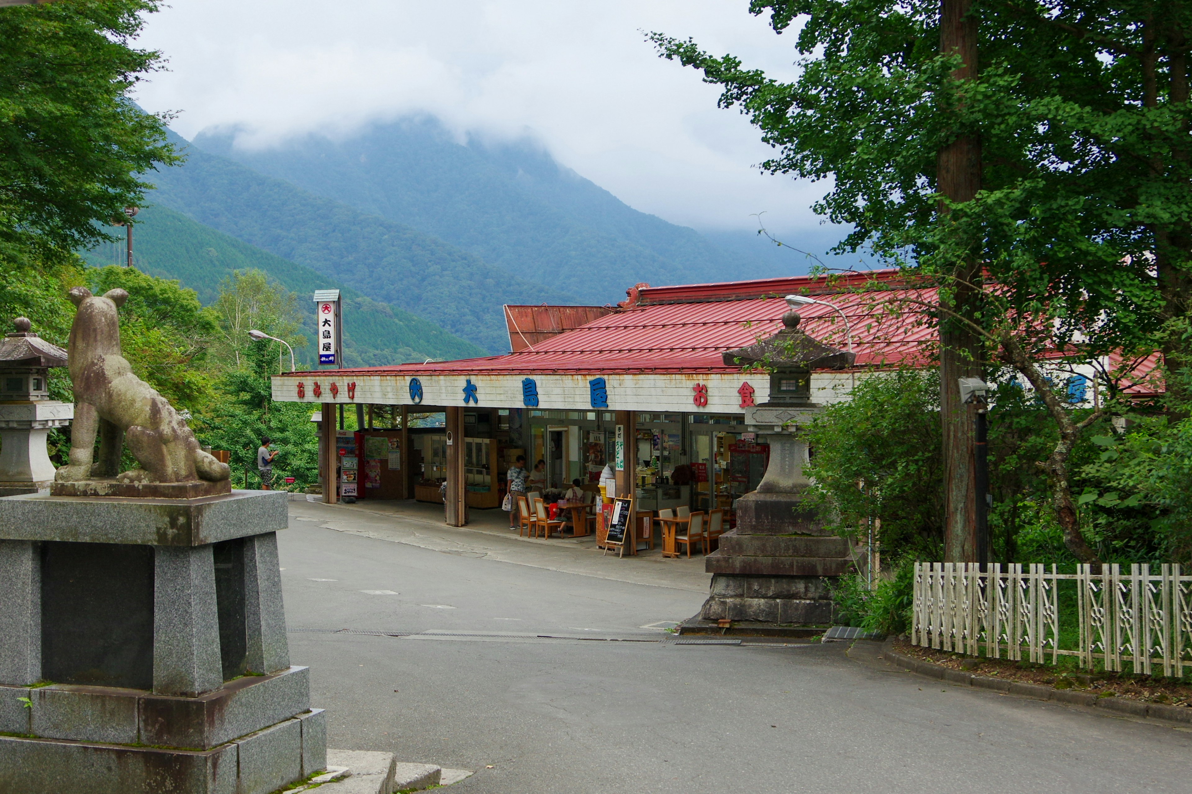 Tienda tradicional con estatuas de piedra en un paisaje montañoso