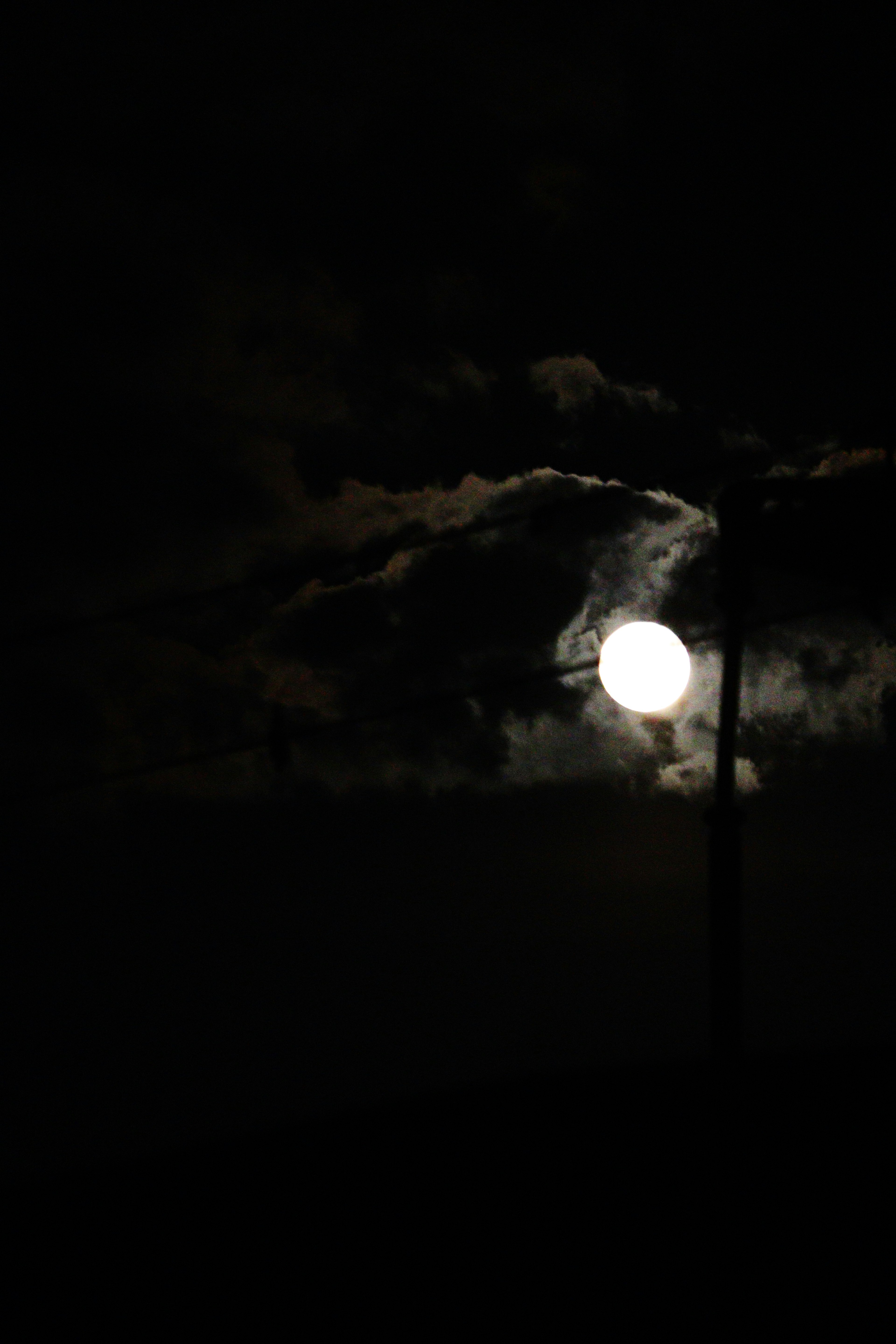 暗い夜空に浮かぶ明るい月と雲