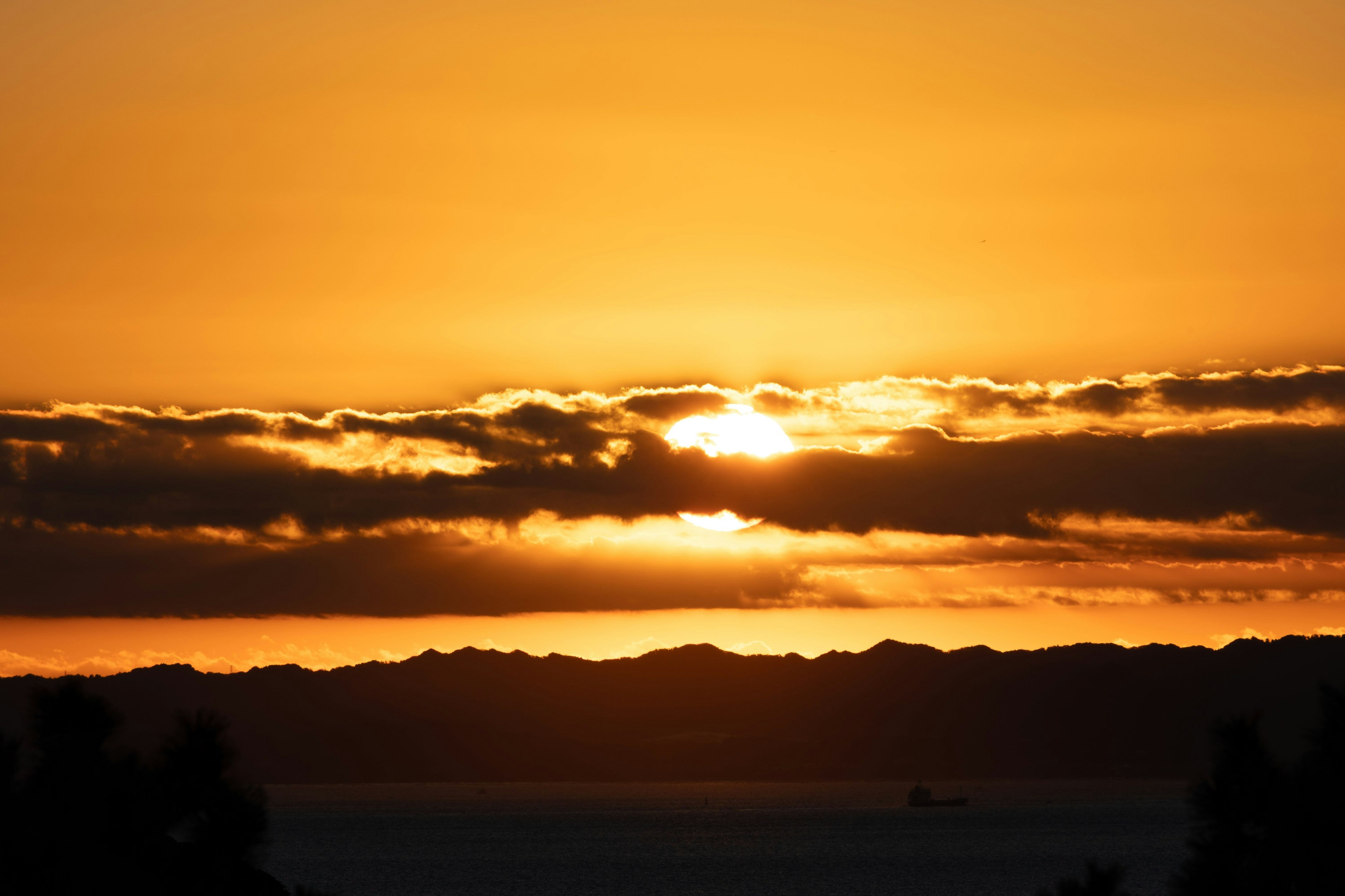 美しい夕日が雲の間から輝くオレンジ色の空