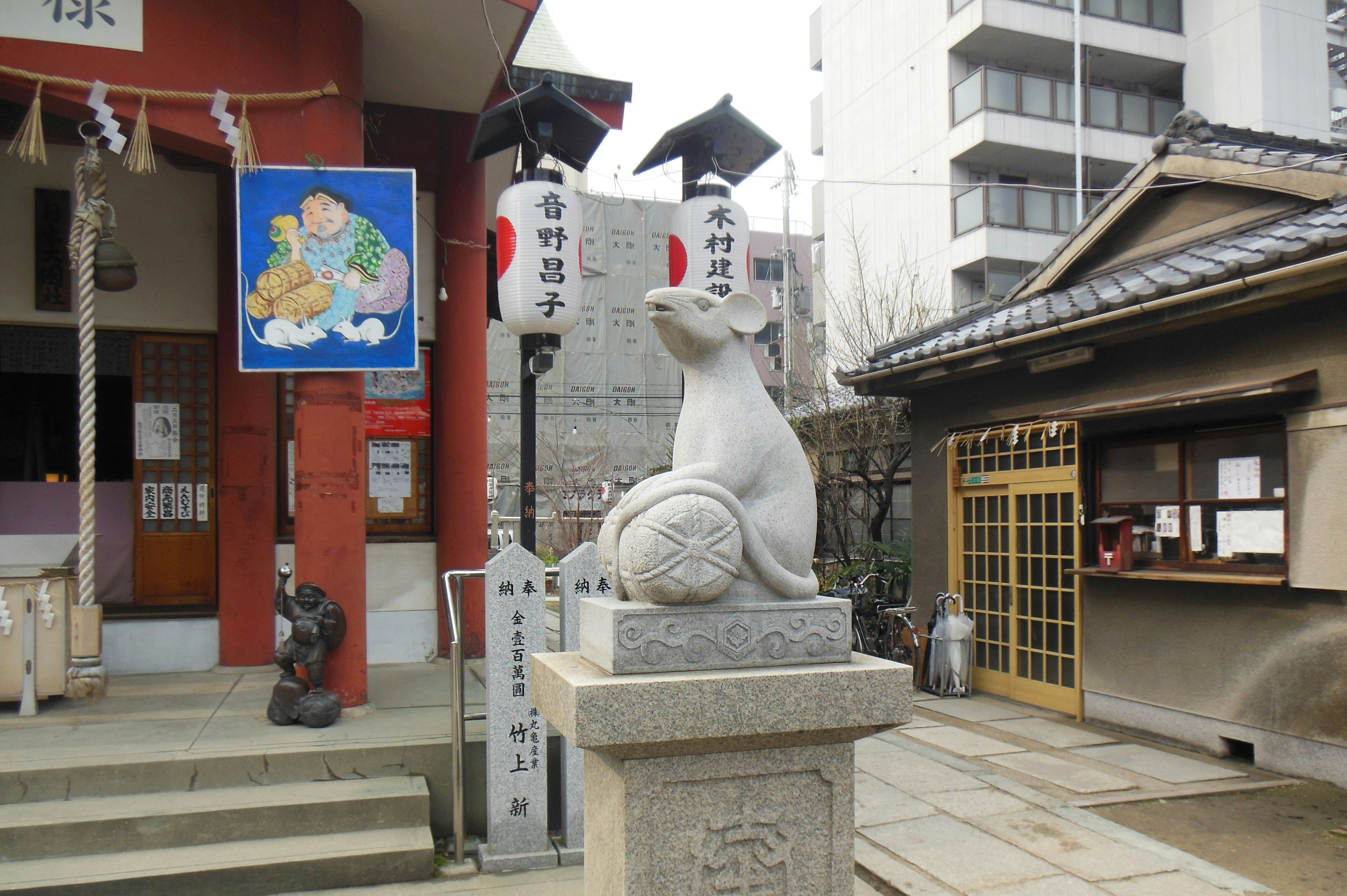 Statue de lapin en pierre à un sanctuaire avec des bâtiments environnants