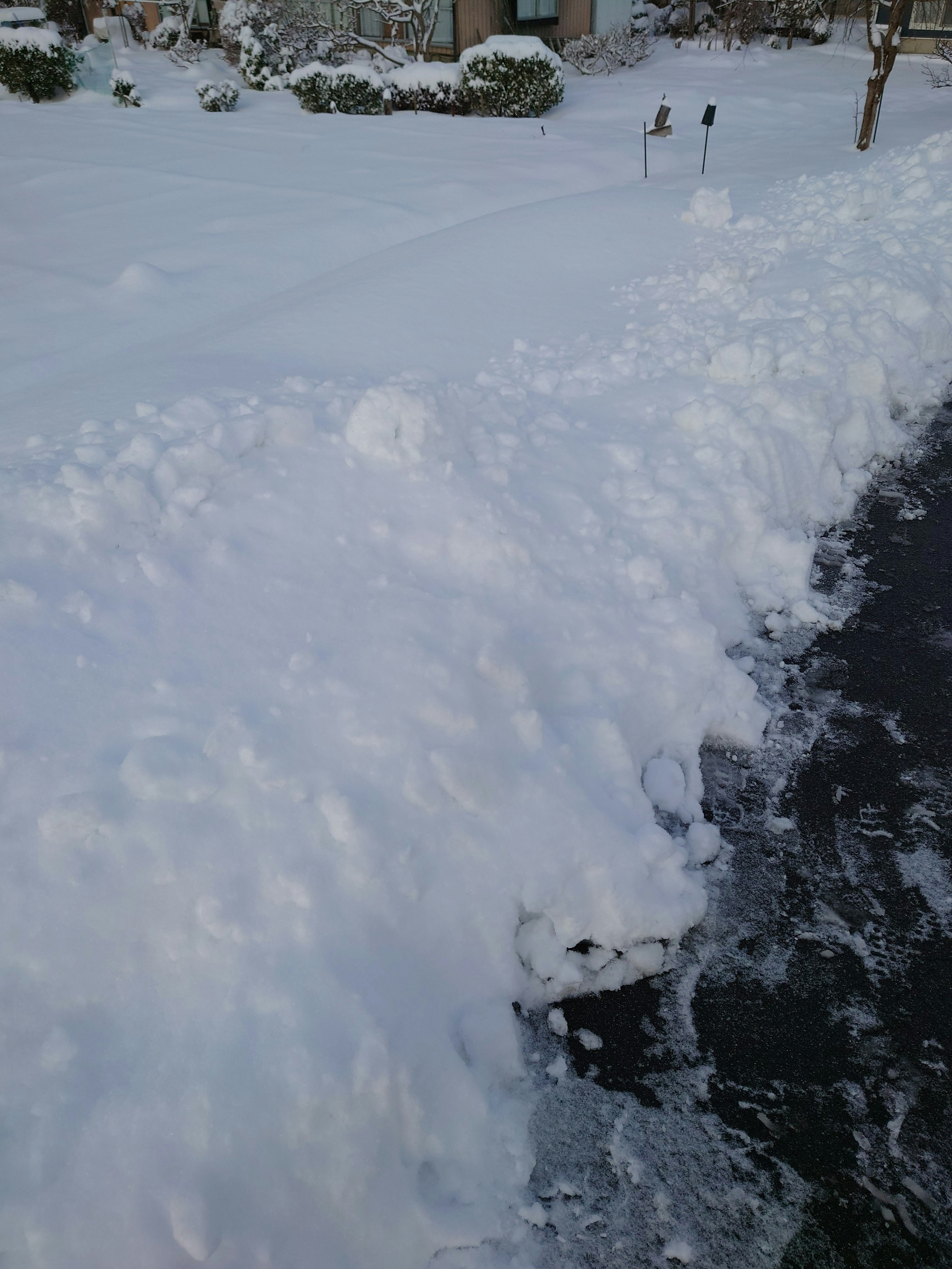 Snow-covered sidewalk with snow piles