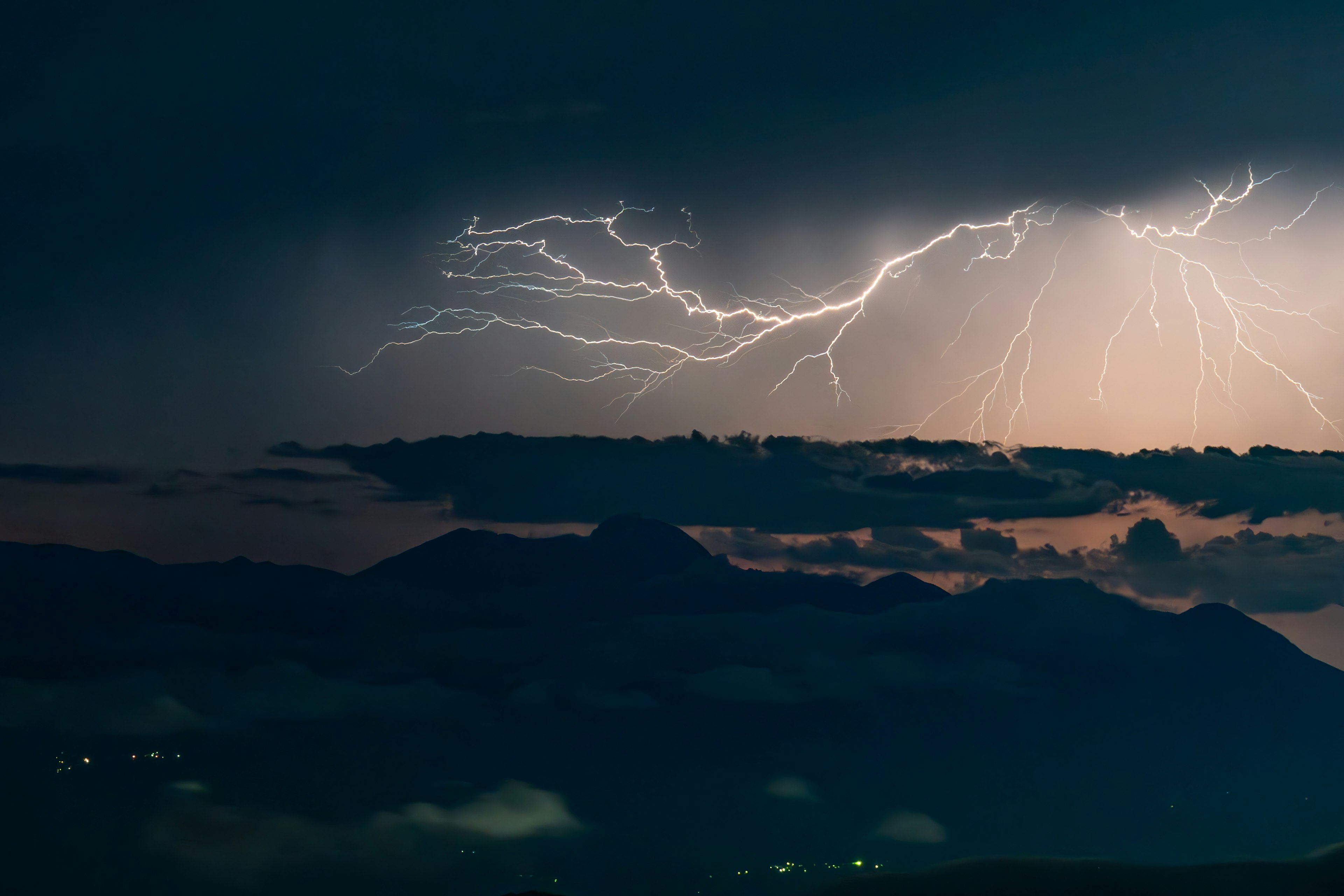 Fulmini drammatici che colpiscono silhouette di montagne scure