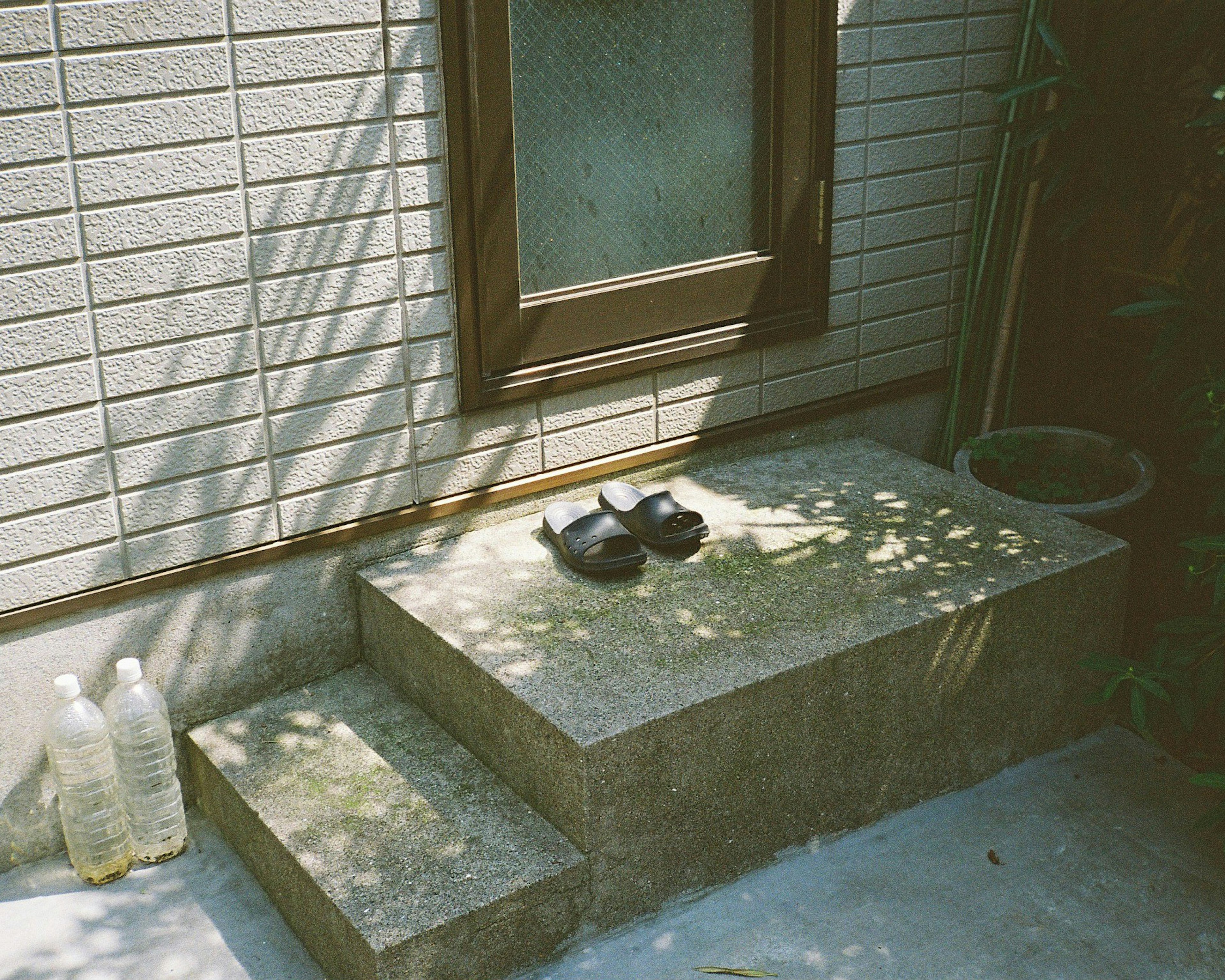 Schwarze Sandalen auf Steinstufen mit Lichtschatten