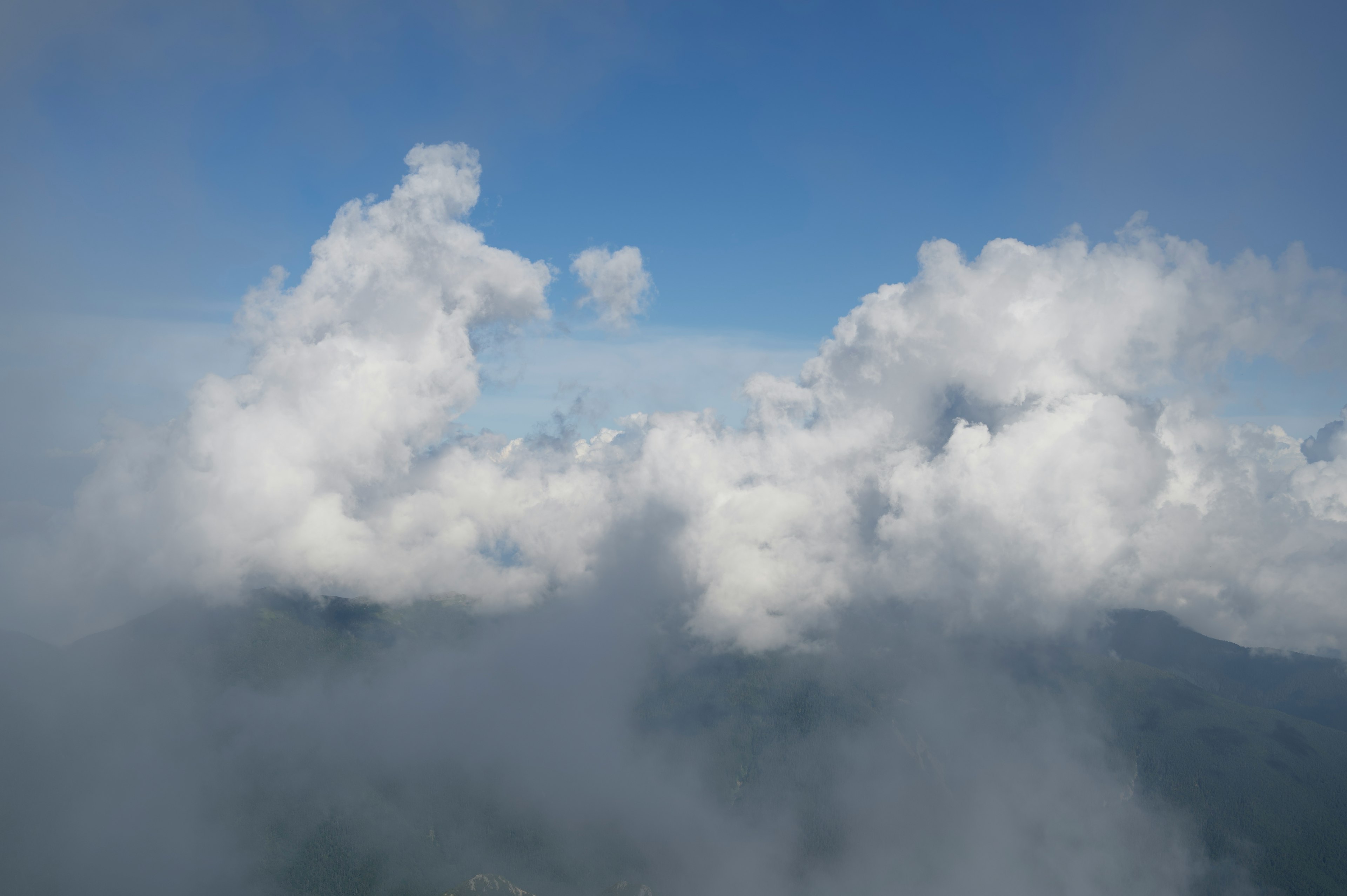 青空に浮かぶ白い雲とその影