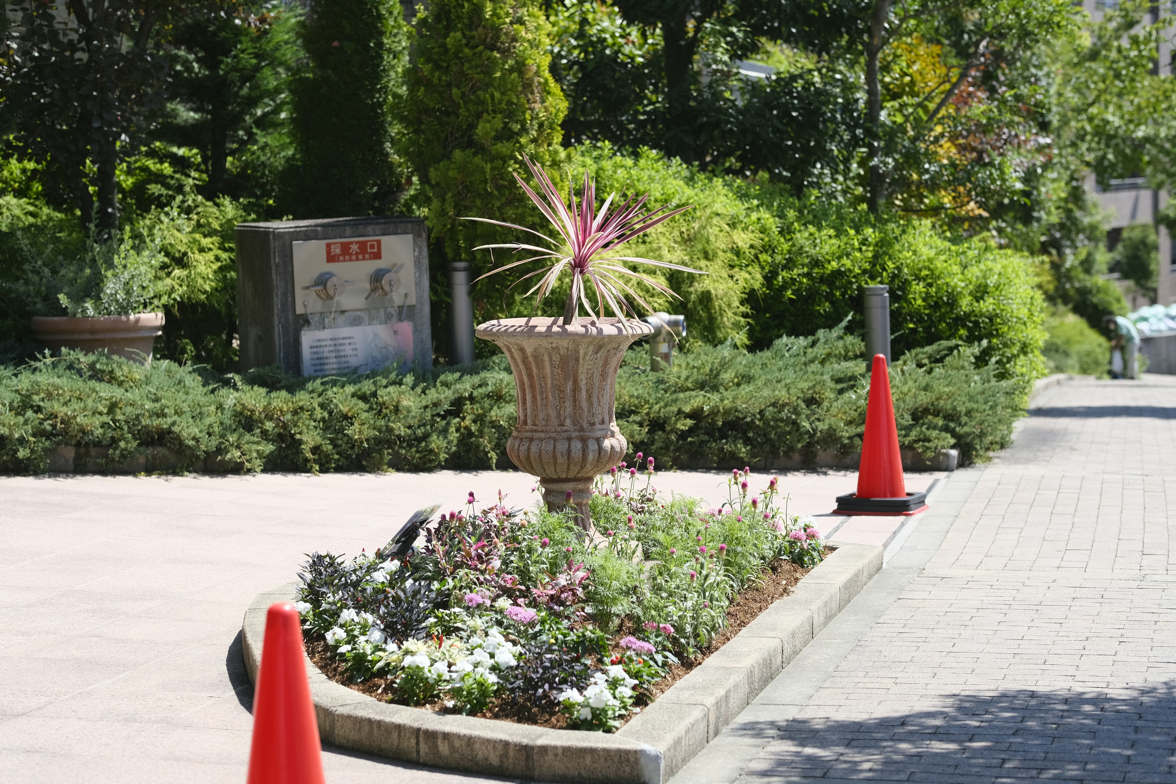 Jarrón decorativo con plantas vibrantes en un entorno de jardín exuberante