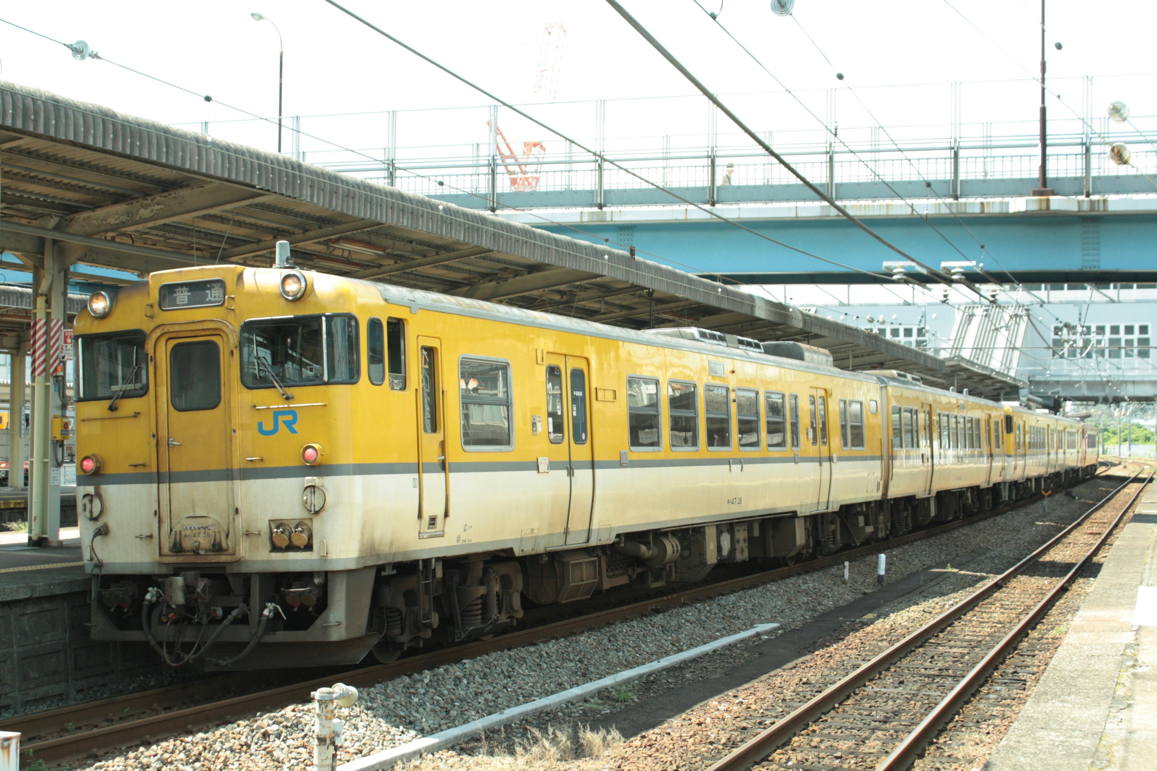 黄色い電車が駅に停車している風景