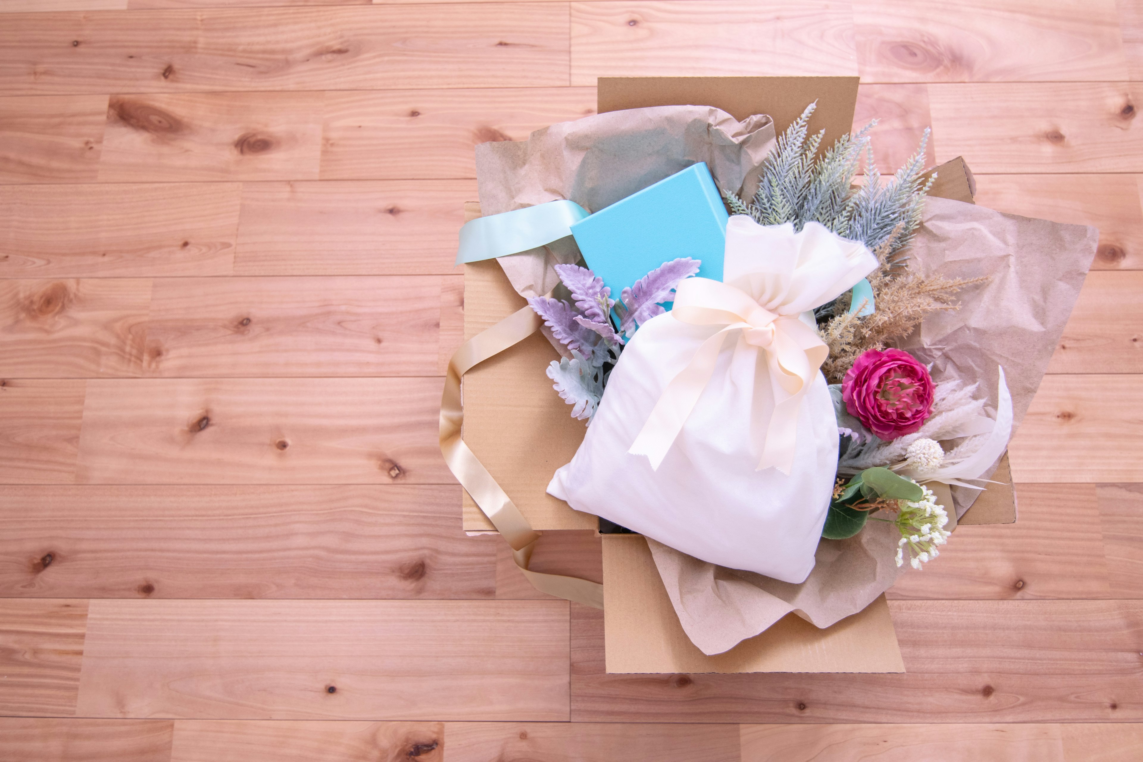 Draufsicht auf eine Box gefüllt mit Blumen und Geschenken