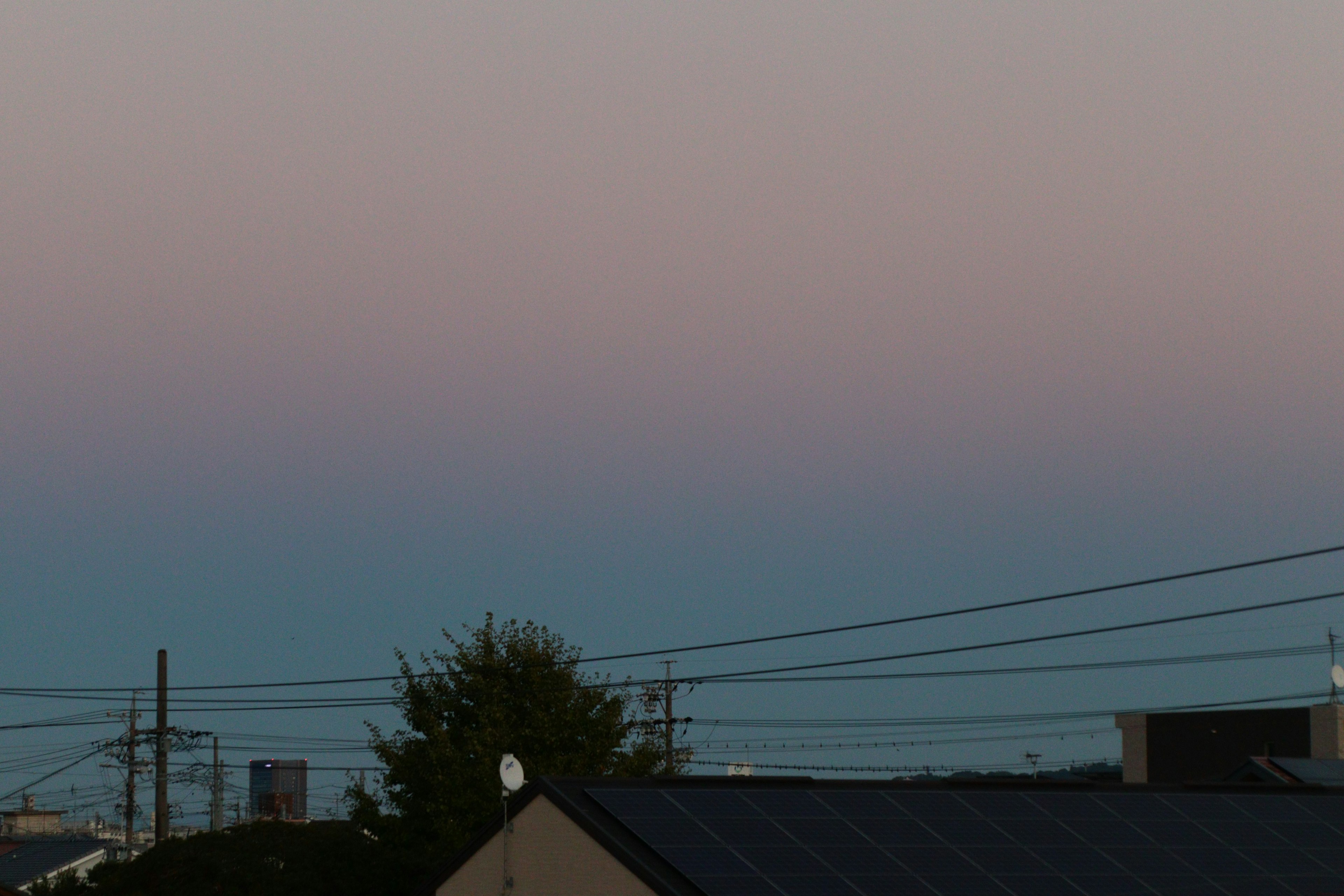 Cielo en degradado que va del azul suave al rosa con edificios en silueta