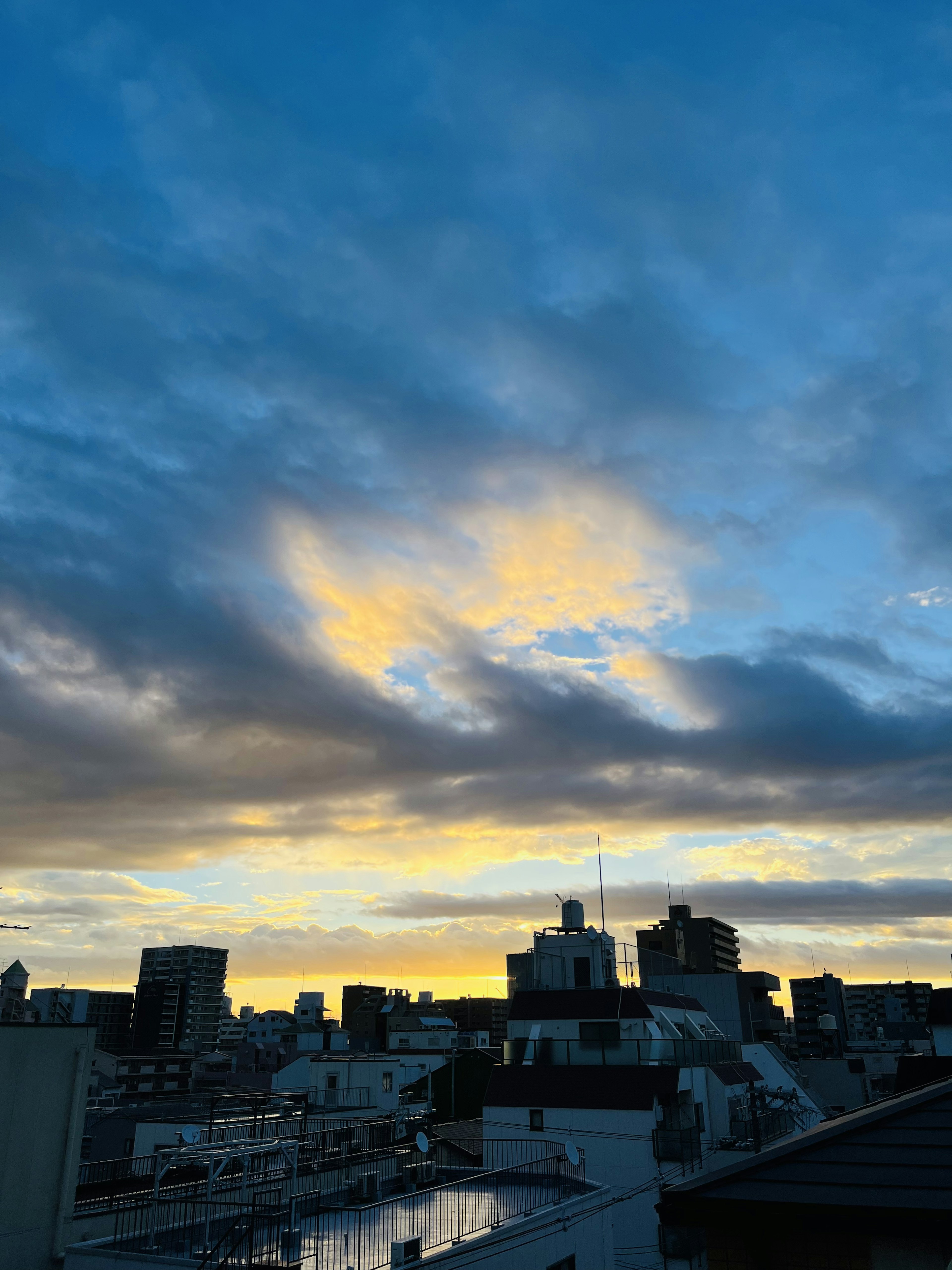 夕焼けに染まる都市の空と建物のシルエット