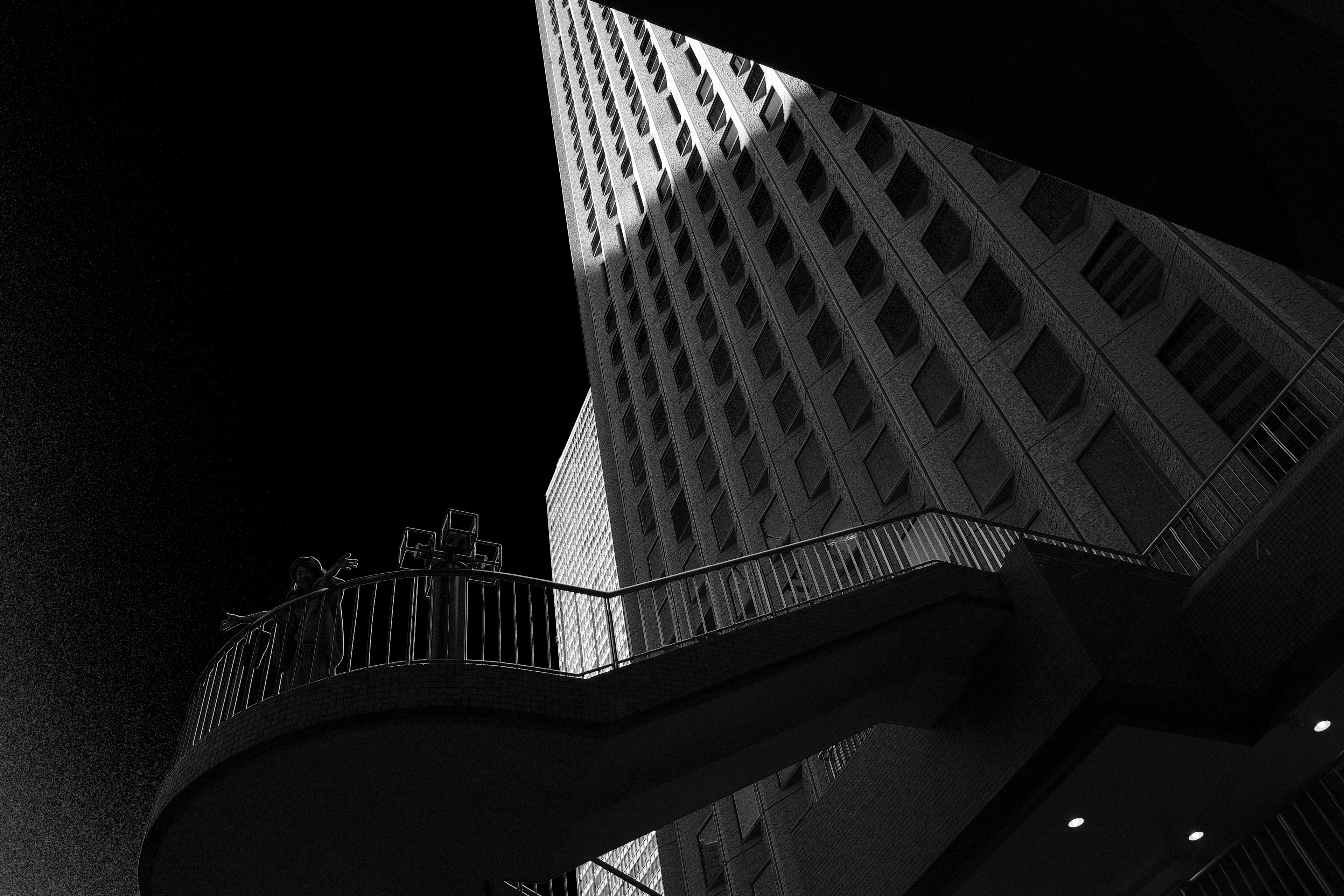 Schwarzweißfoto eines Wolkenkratzers und einer Wendeltreppe