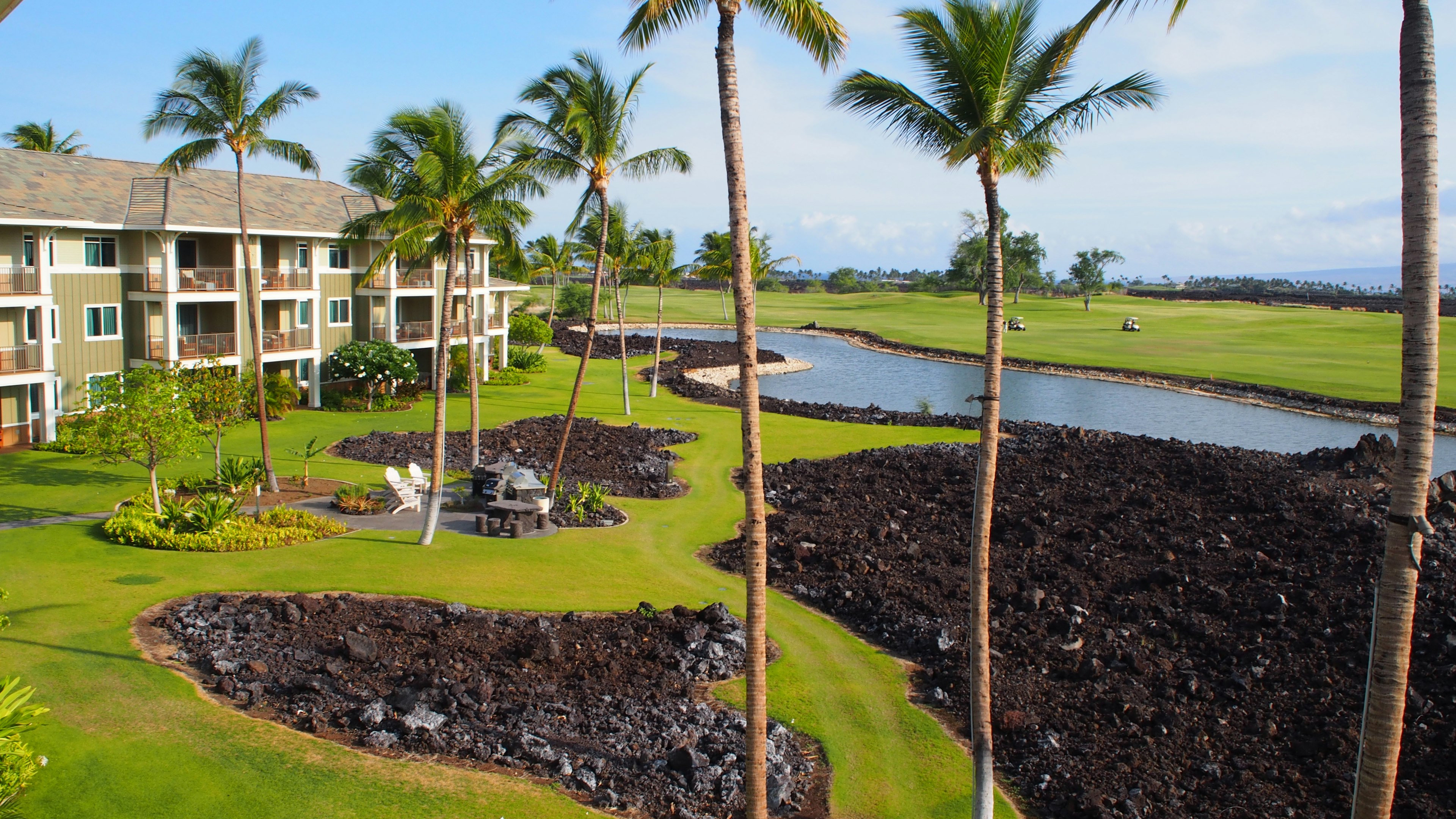 Paisaje de un resort hawaiano con palmeras y un amplio jardín