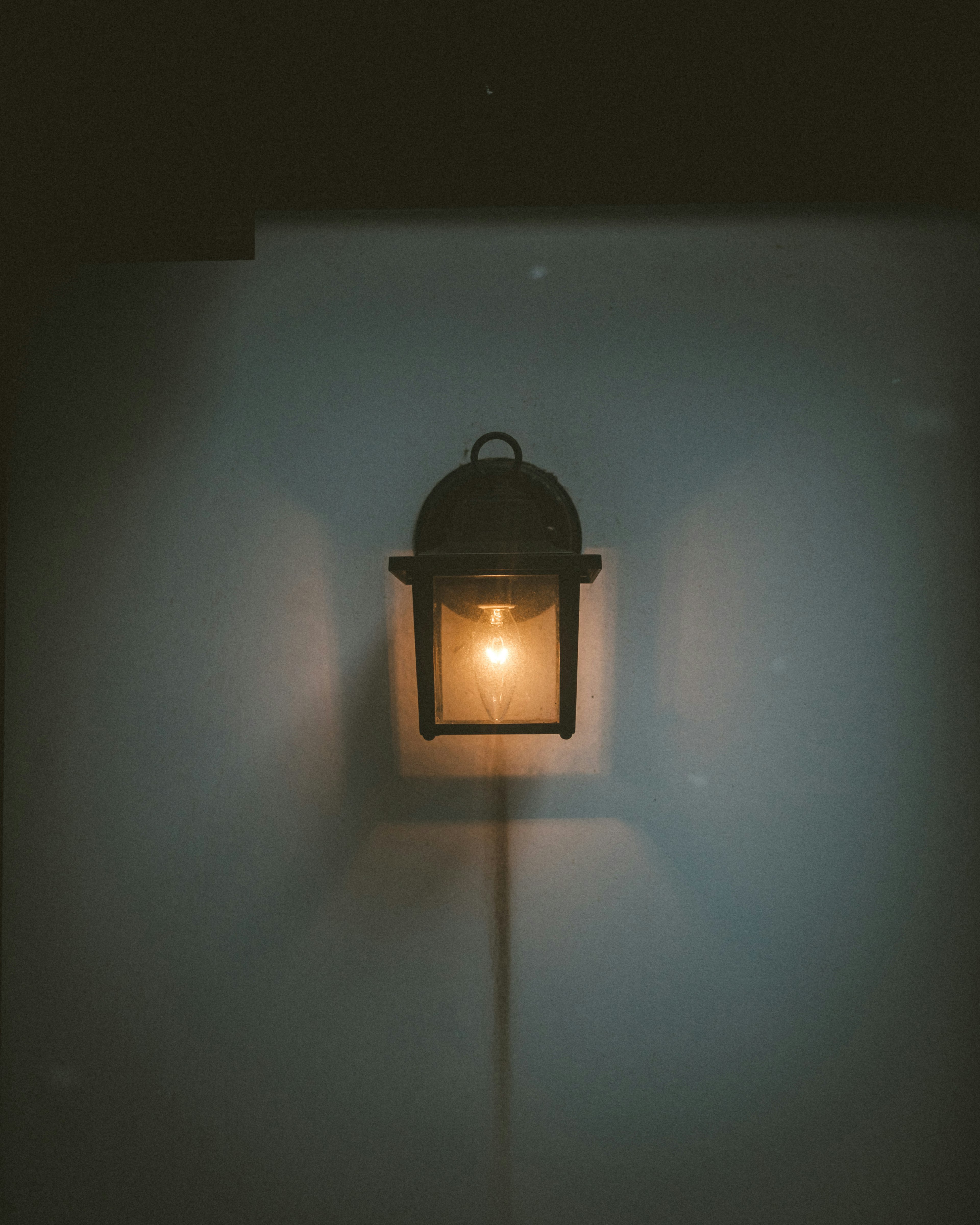 A wall-mounted lantern emitting a soft glow