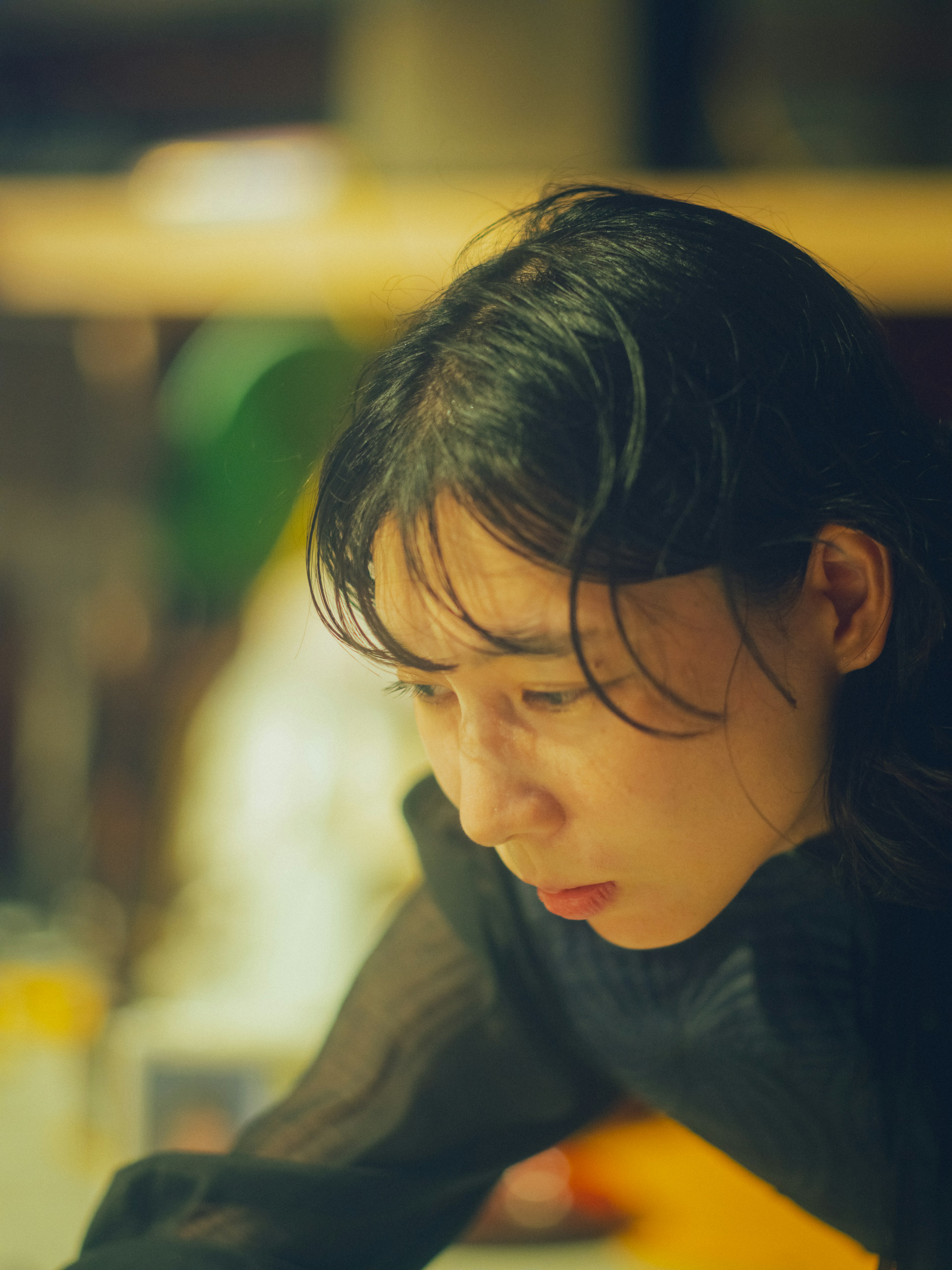 A woman with wet hair focused intently on a task