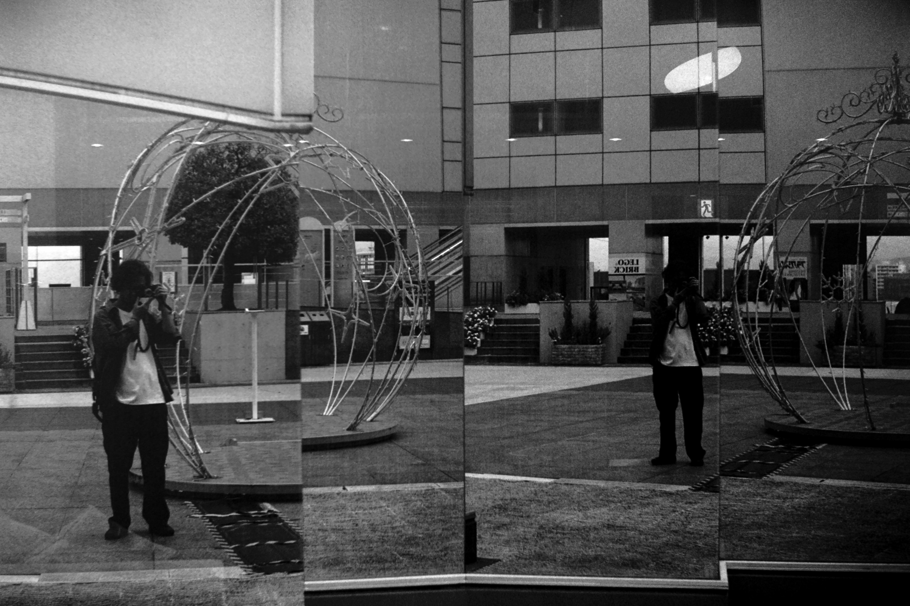 A metallic globe sculpture in a modern lobby with a person standing in front