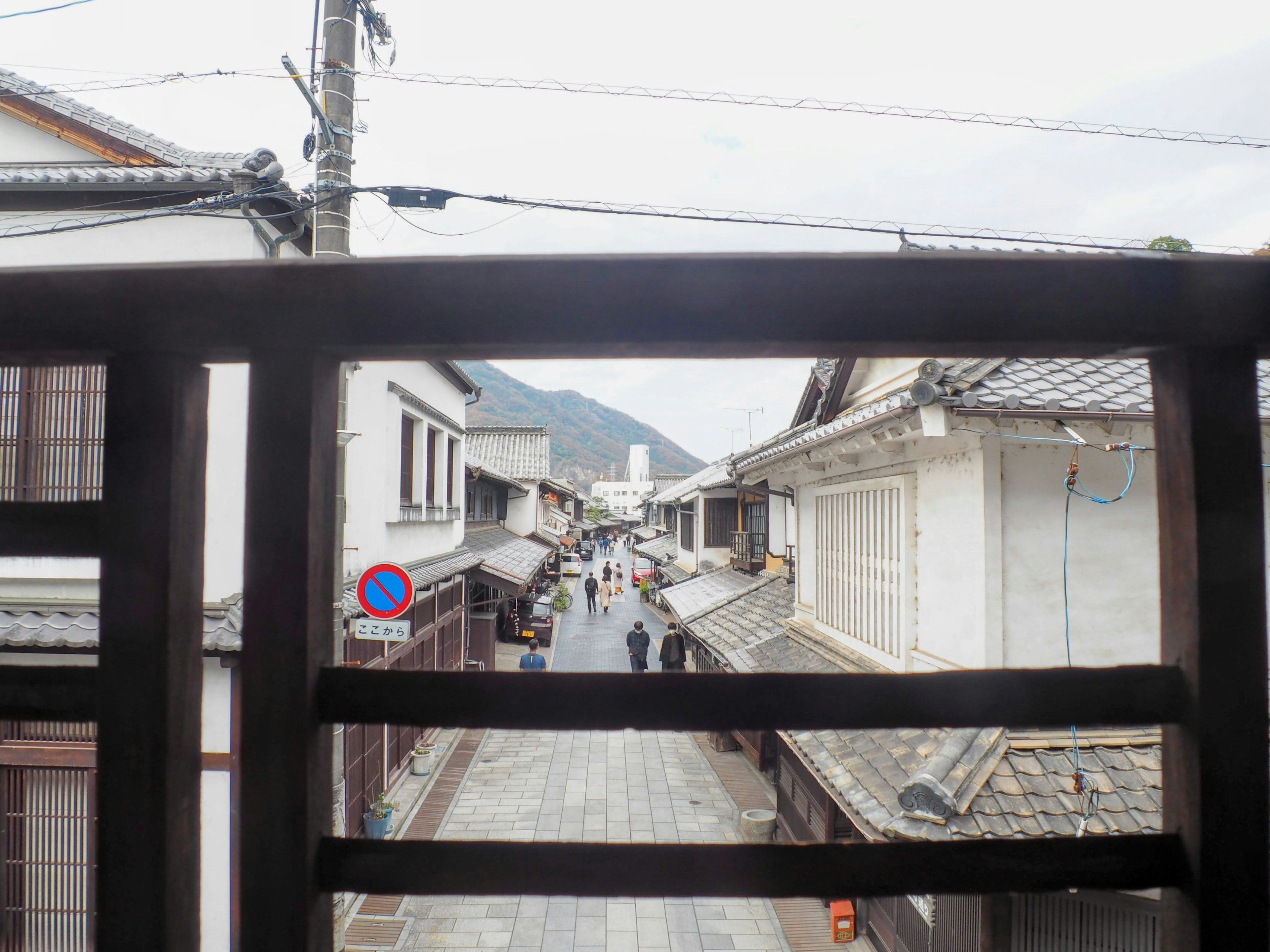 Vista de una calle tranquila y montañas a través de una cerca de madera