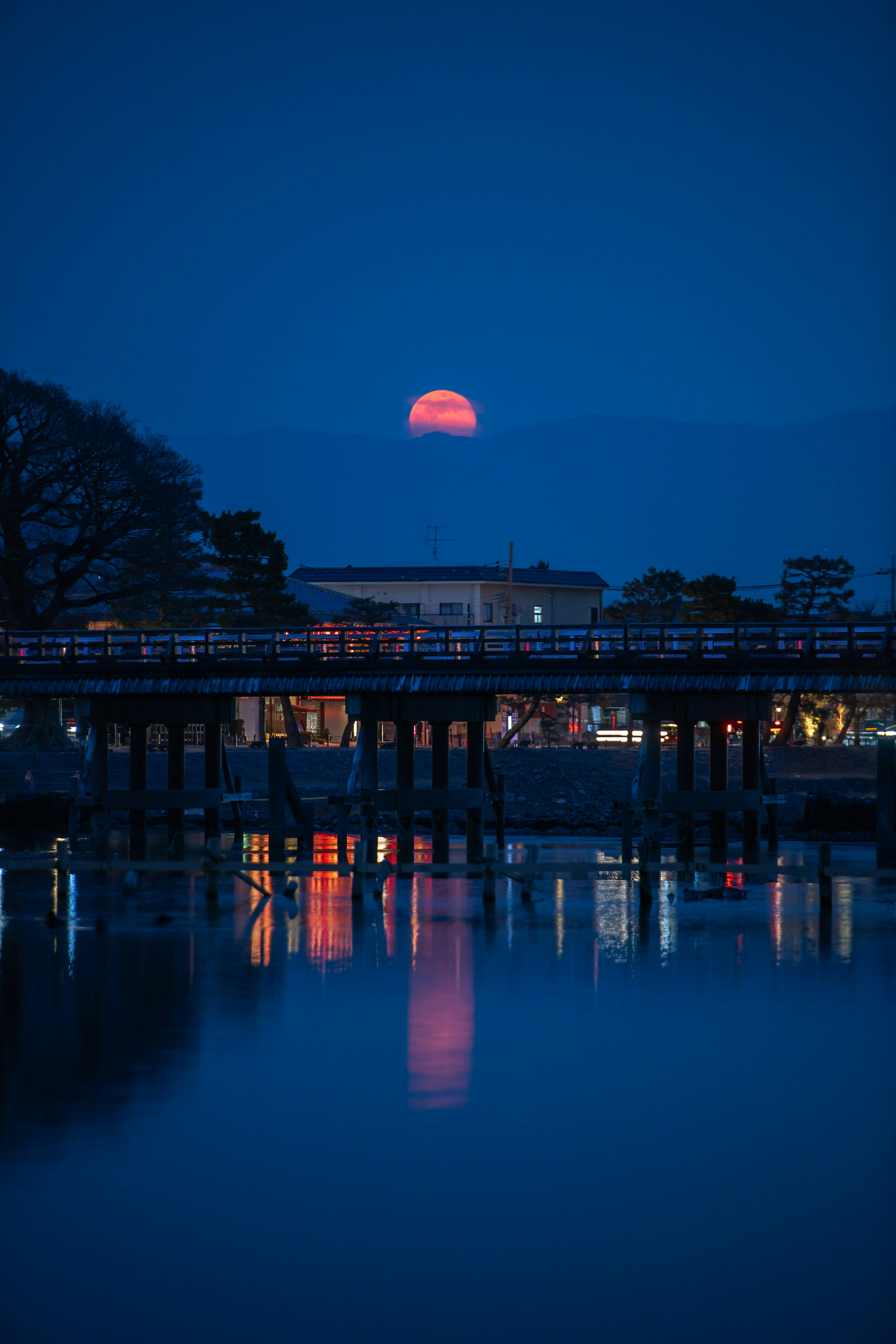 青い夜空に浮かぶ夕日の反射が水面に映る美しい景色