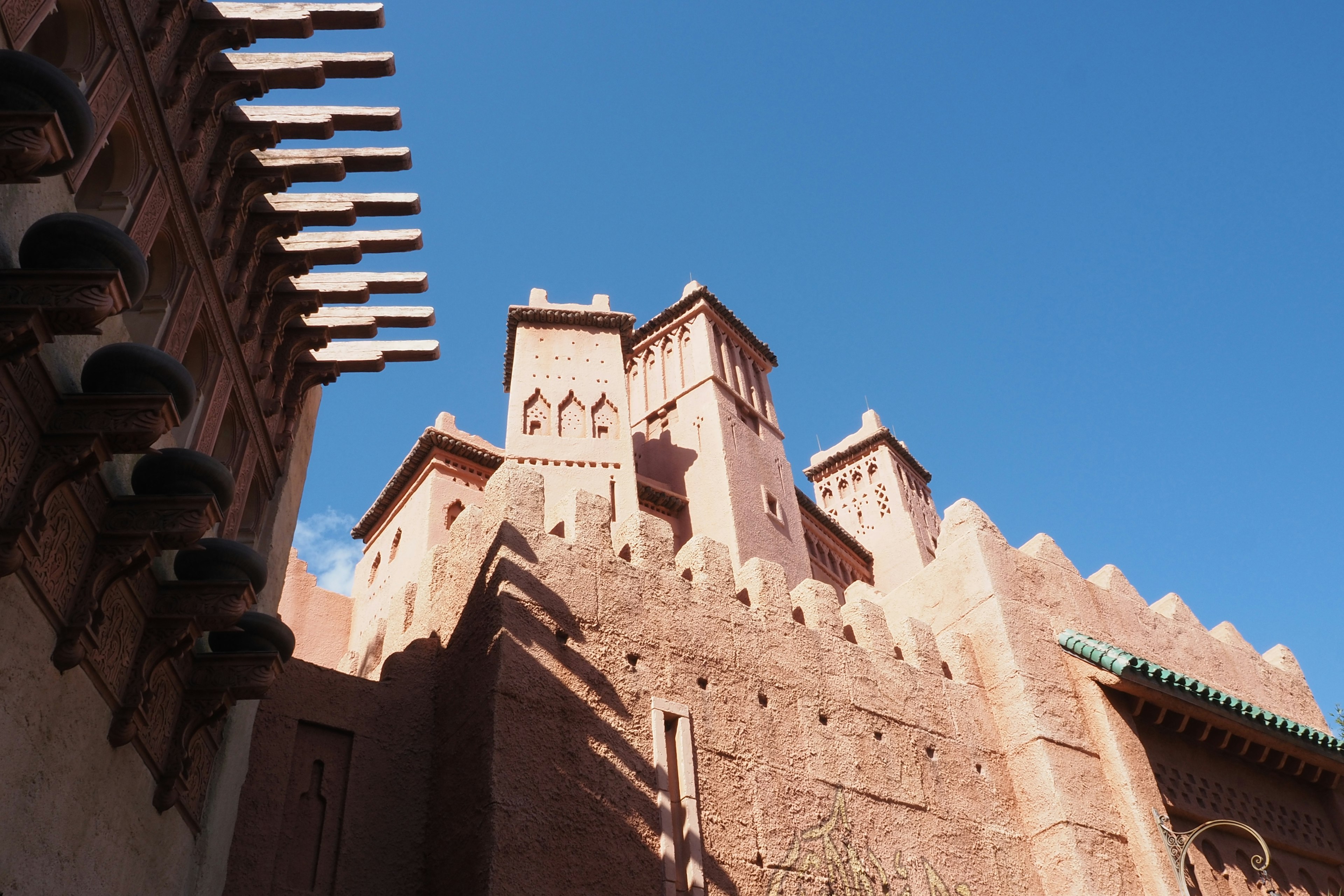 Red earth fortress with tall towers against a blue sky