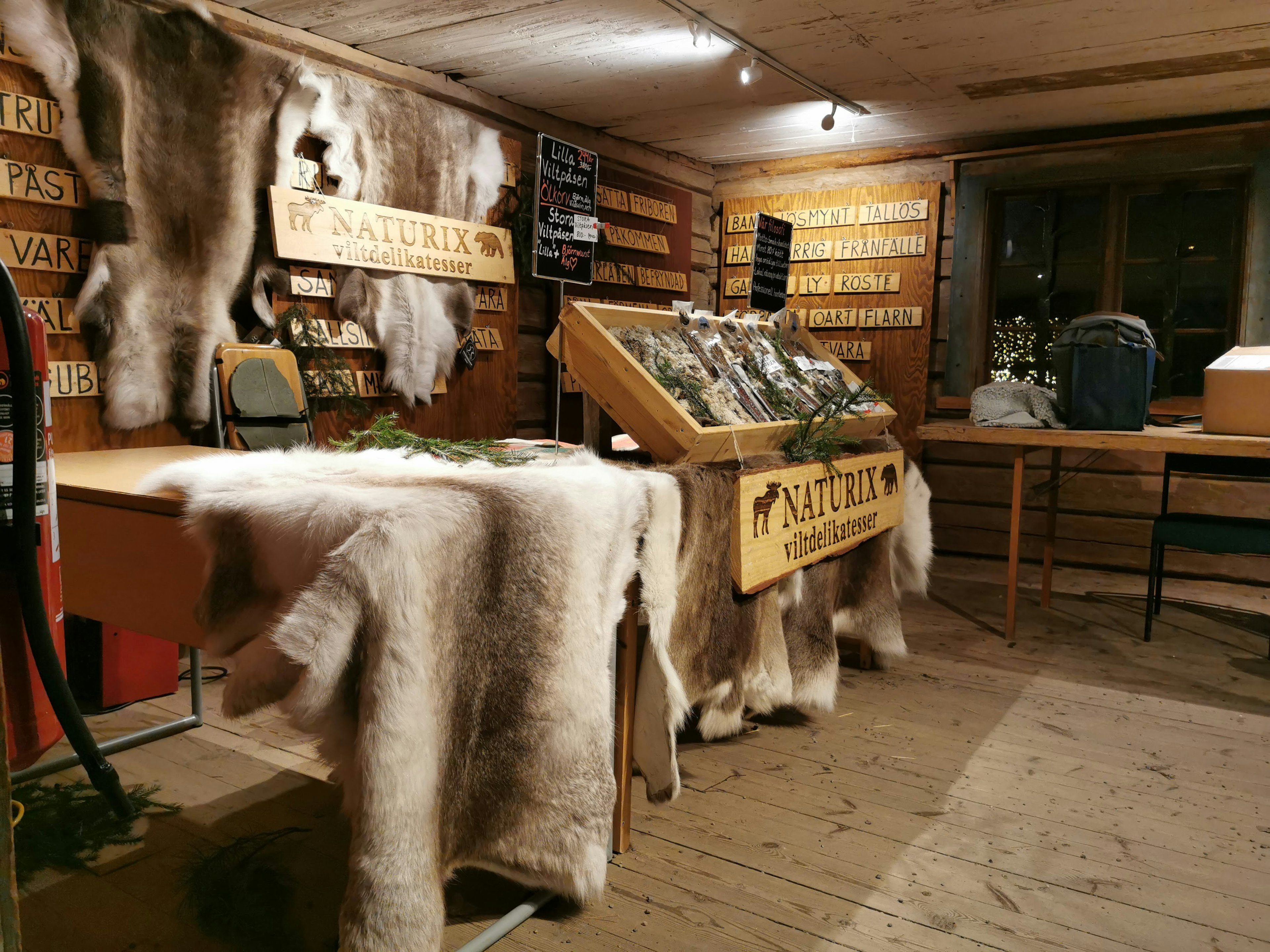 Intérieur d'un magasin avec des murs en bois et des décorations en fourrure présentant des produits sur une table