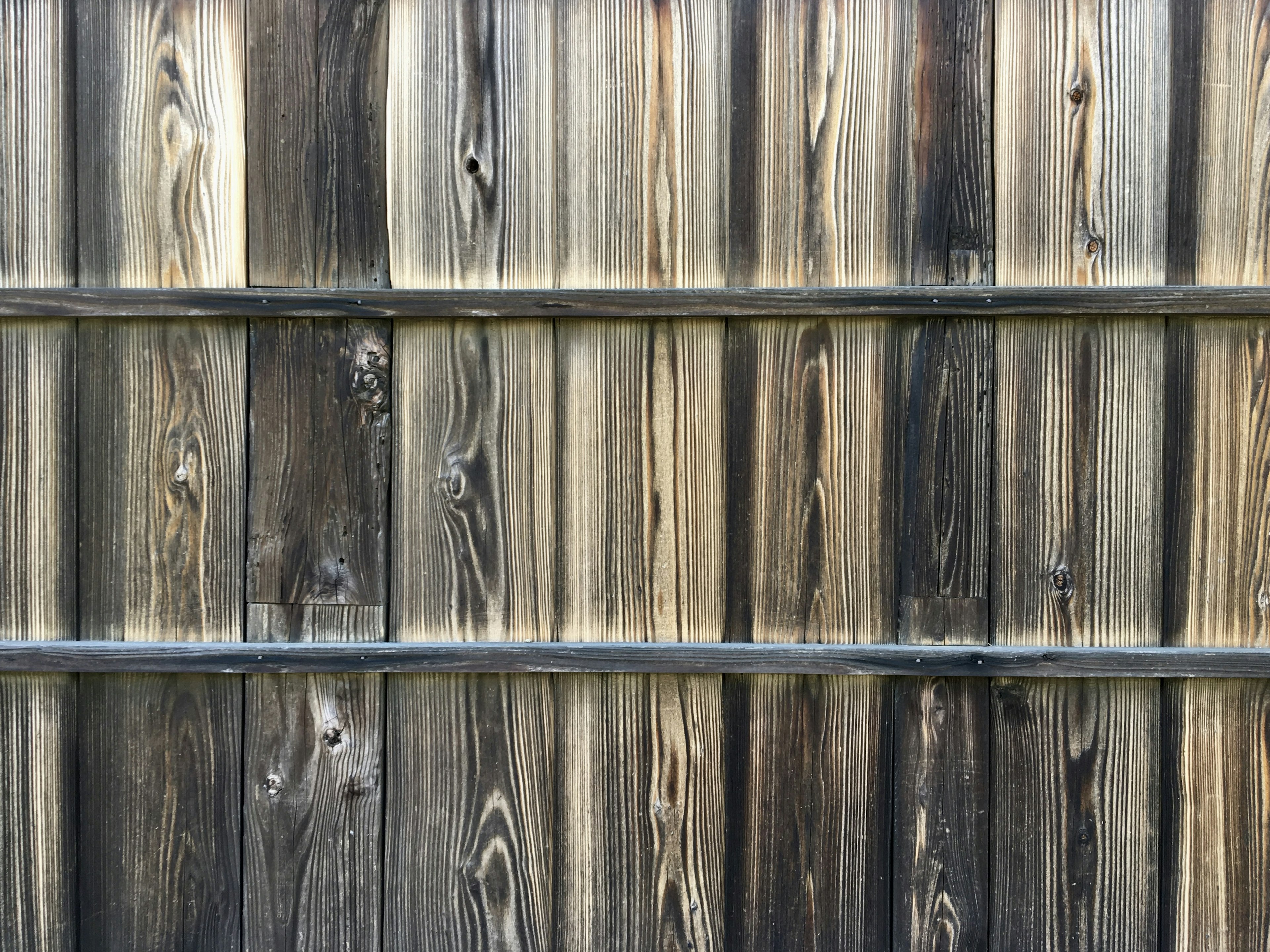 Texture dettagliata e variazioni di colore di una recinzione in legno