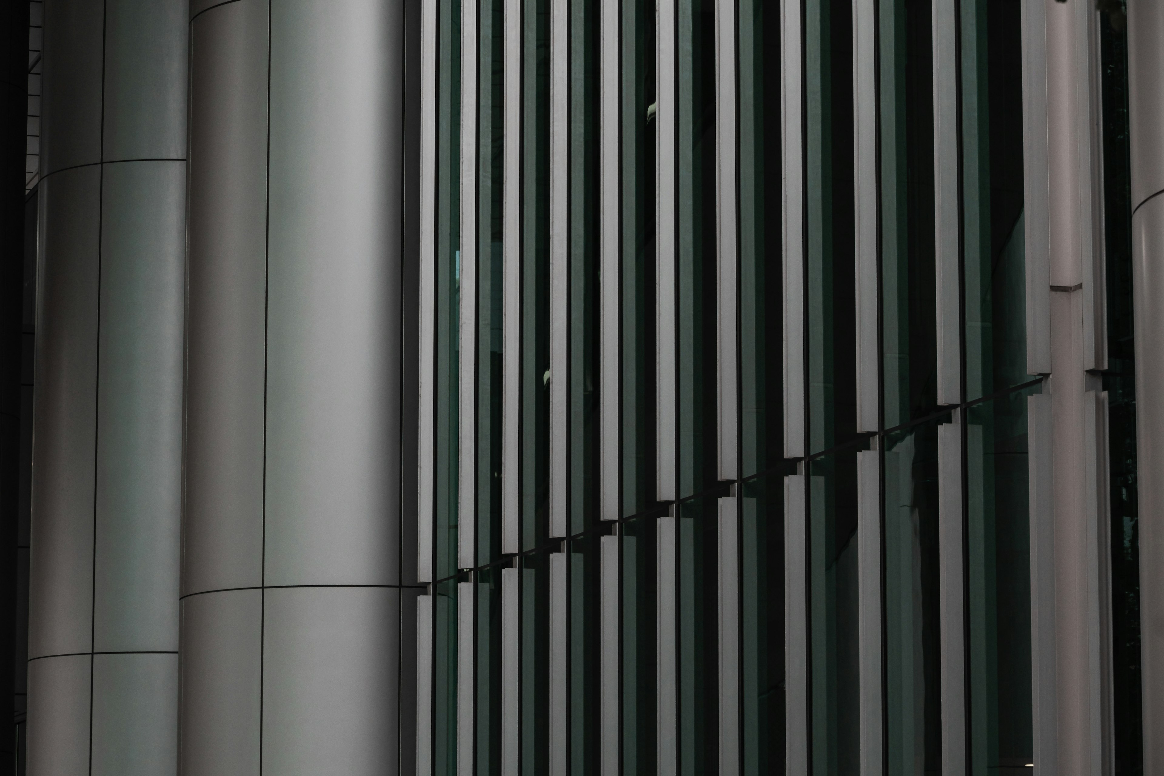 Vertical stripes along a modern building's facade with smooth metal surfaces