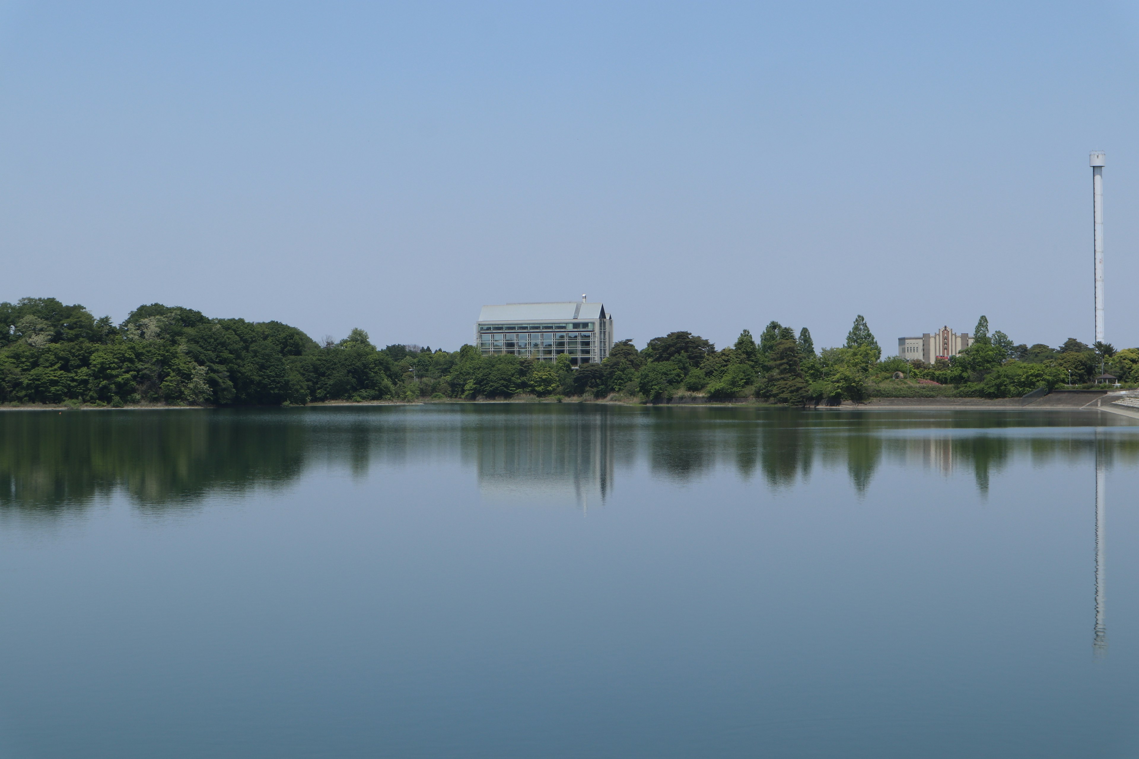 Paysage de lac calme avec des reflets et un ciel dégagé