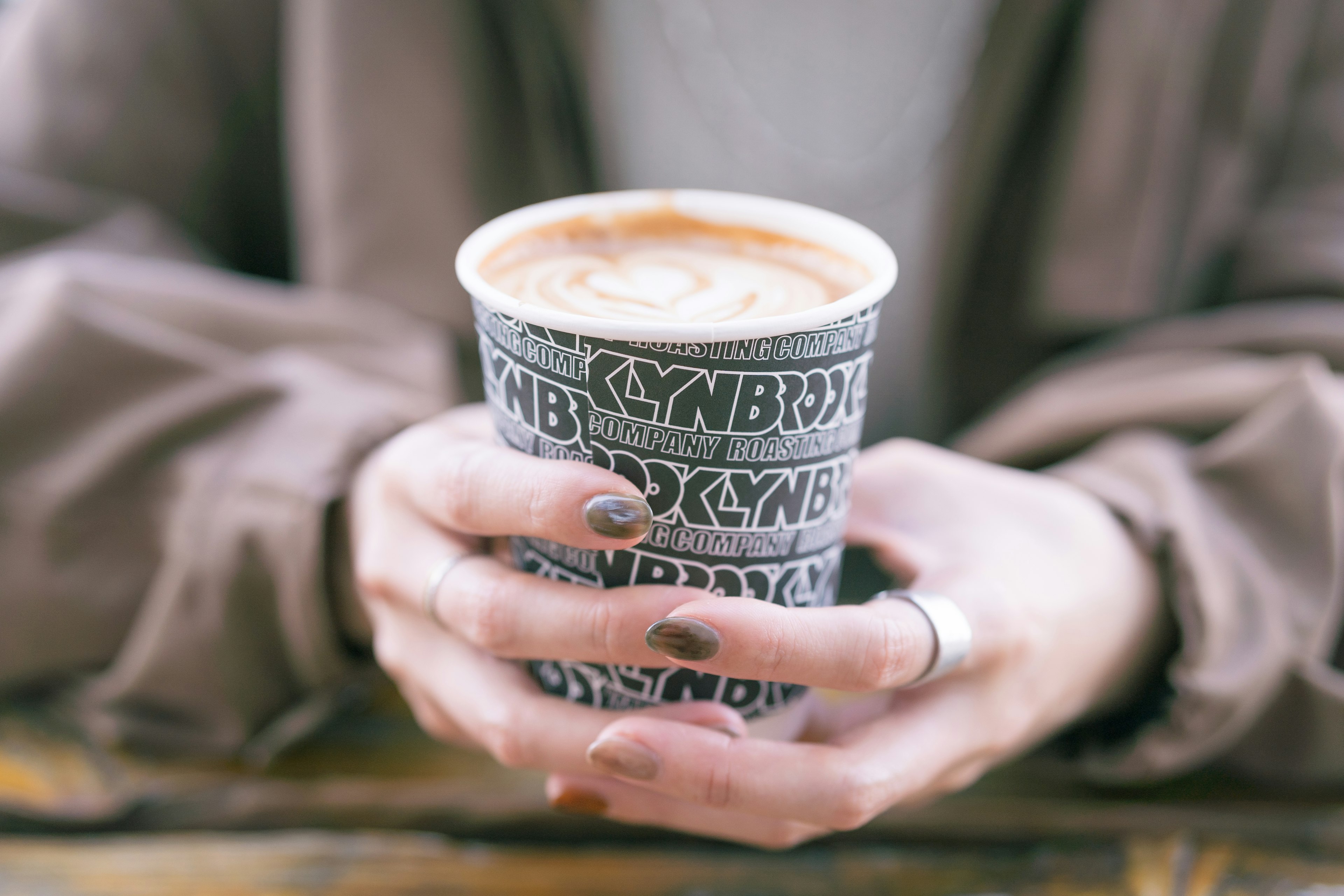 Nahaufnahme von Händen, die eine Tasse mit einem heißen Getränk halten