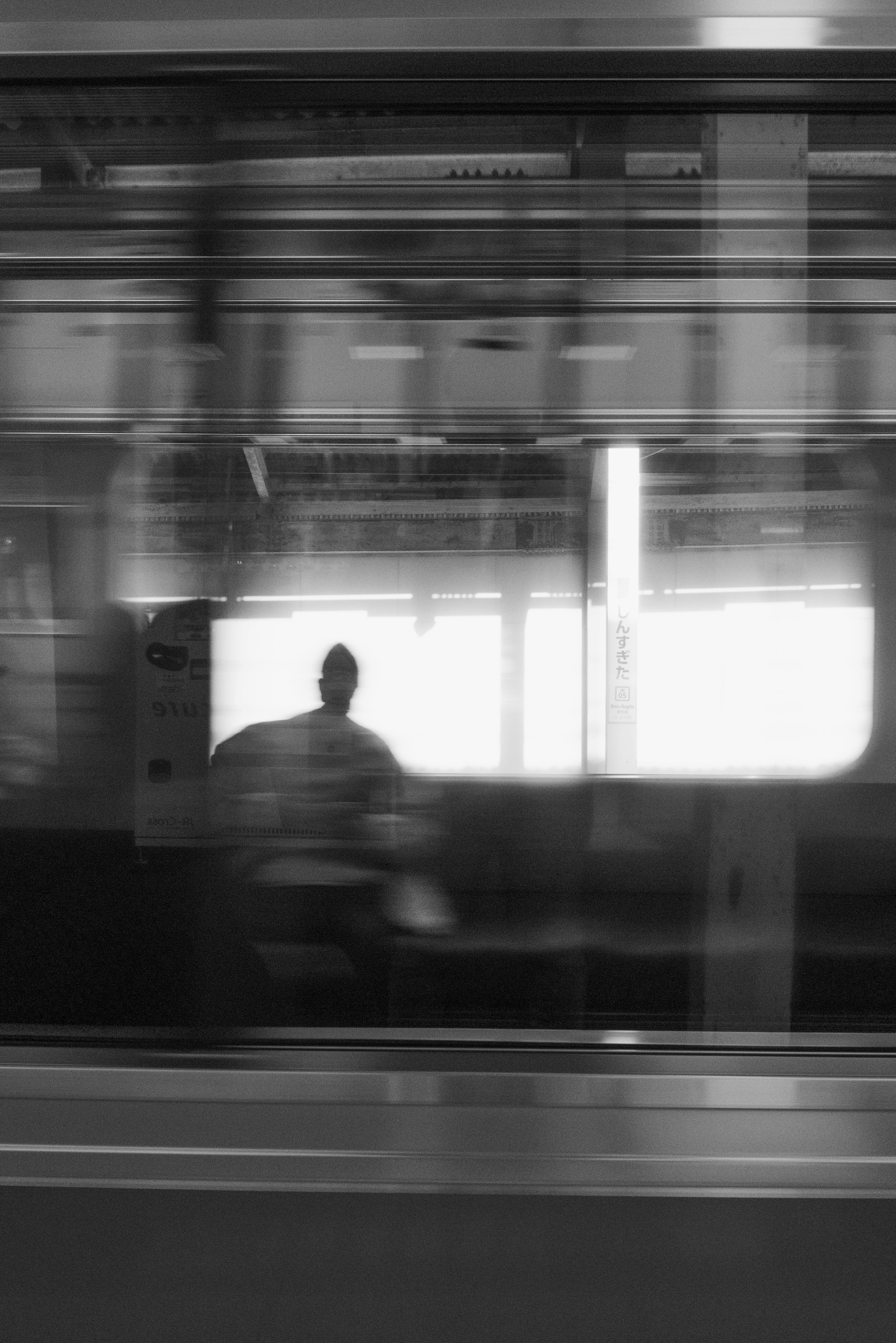 Sombra de una persona sentada dentro de un tren en blanco y negro