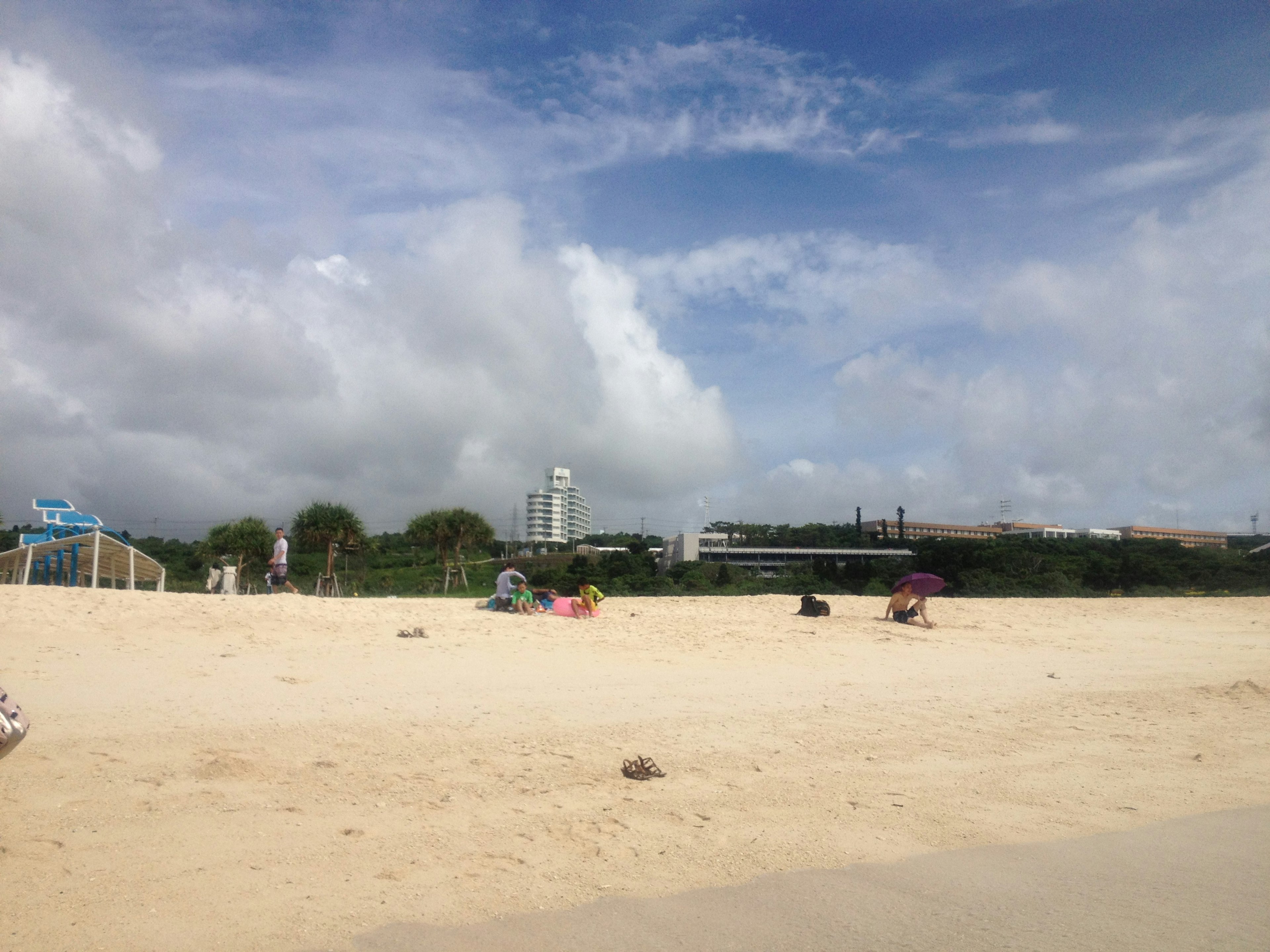 Scène de plage avec ciel bleu et nuages blancs personnes sur le sable