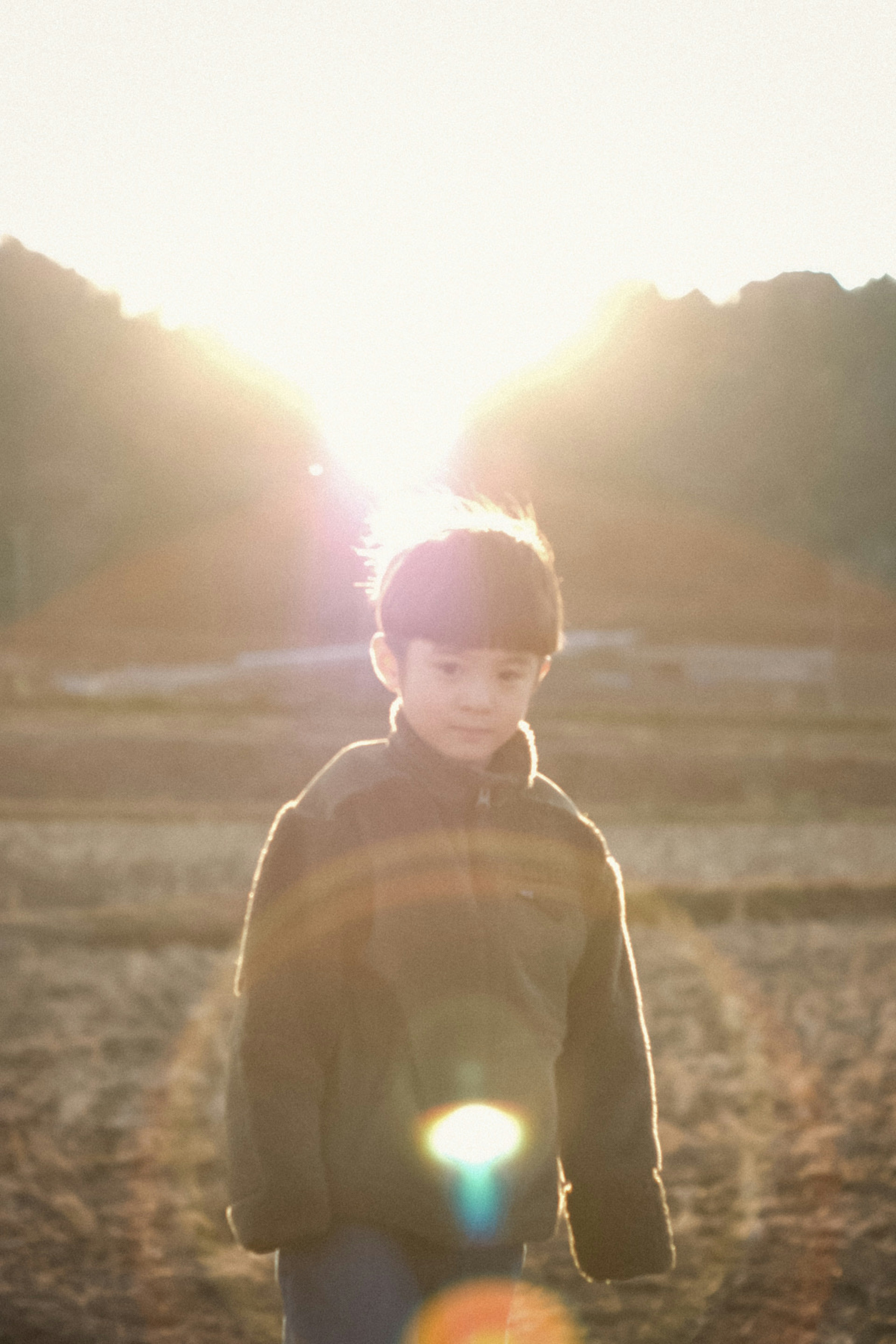 夕日を背にした少年が立っている風景