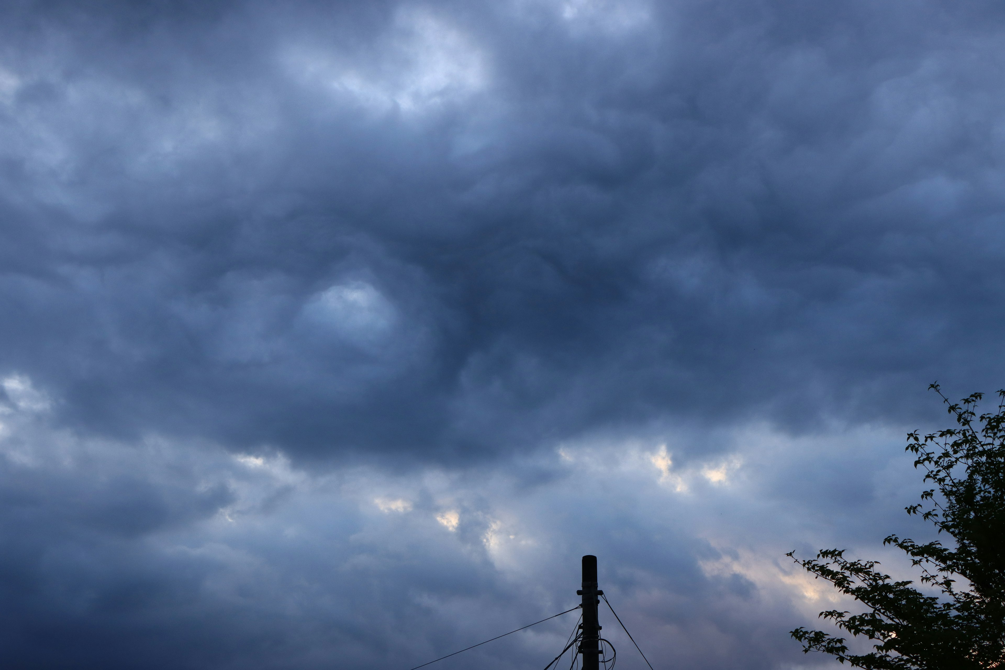 Ciel couvert de nuages sombres avec la silhouette d'un poteau électrique