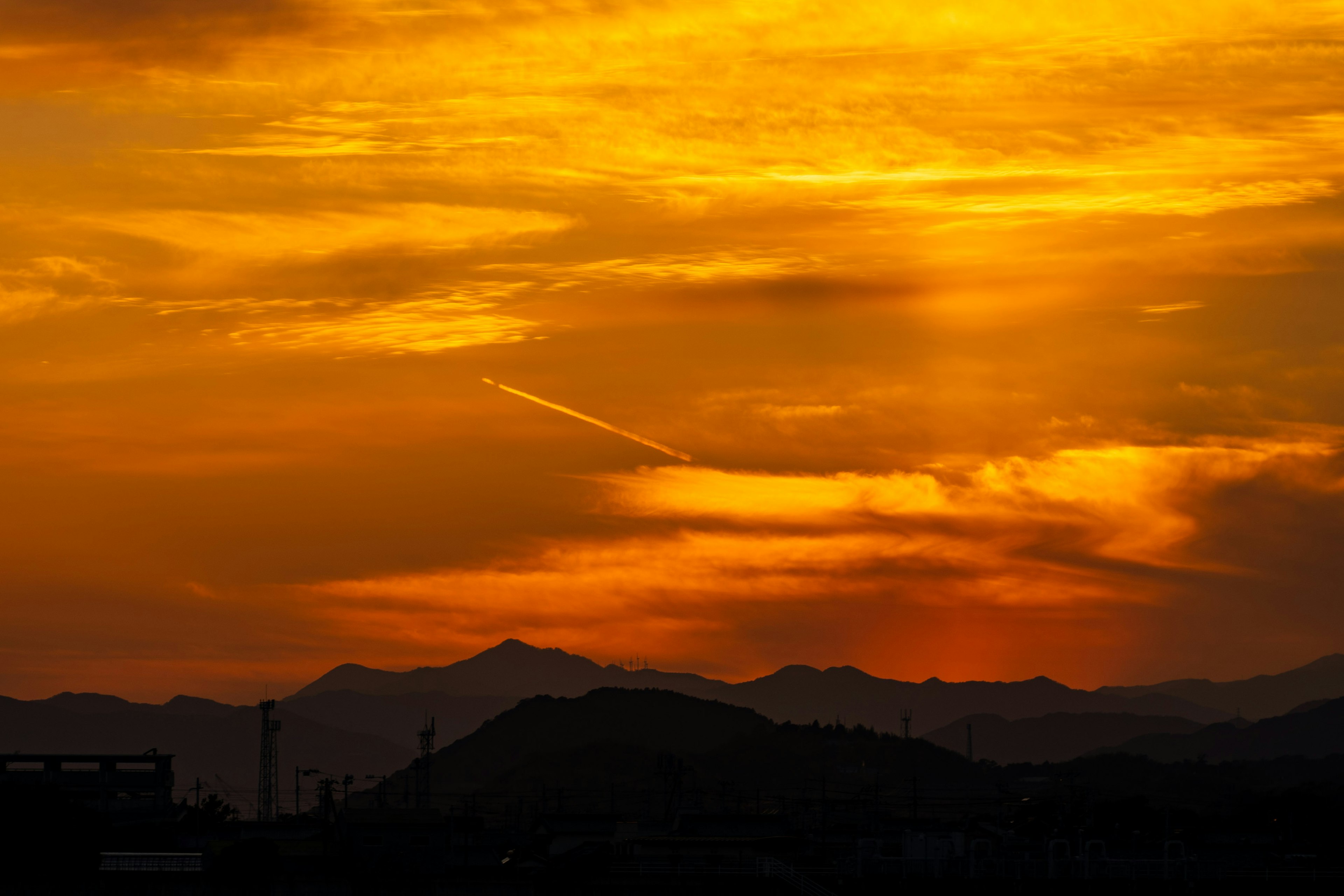 夕焼けの美しいオレンジ色の空と山々のシルエット