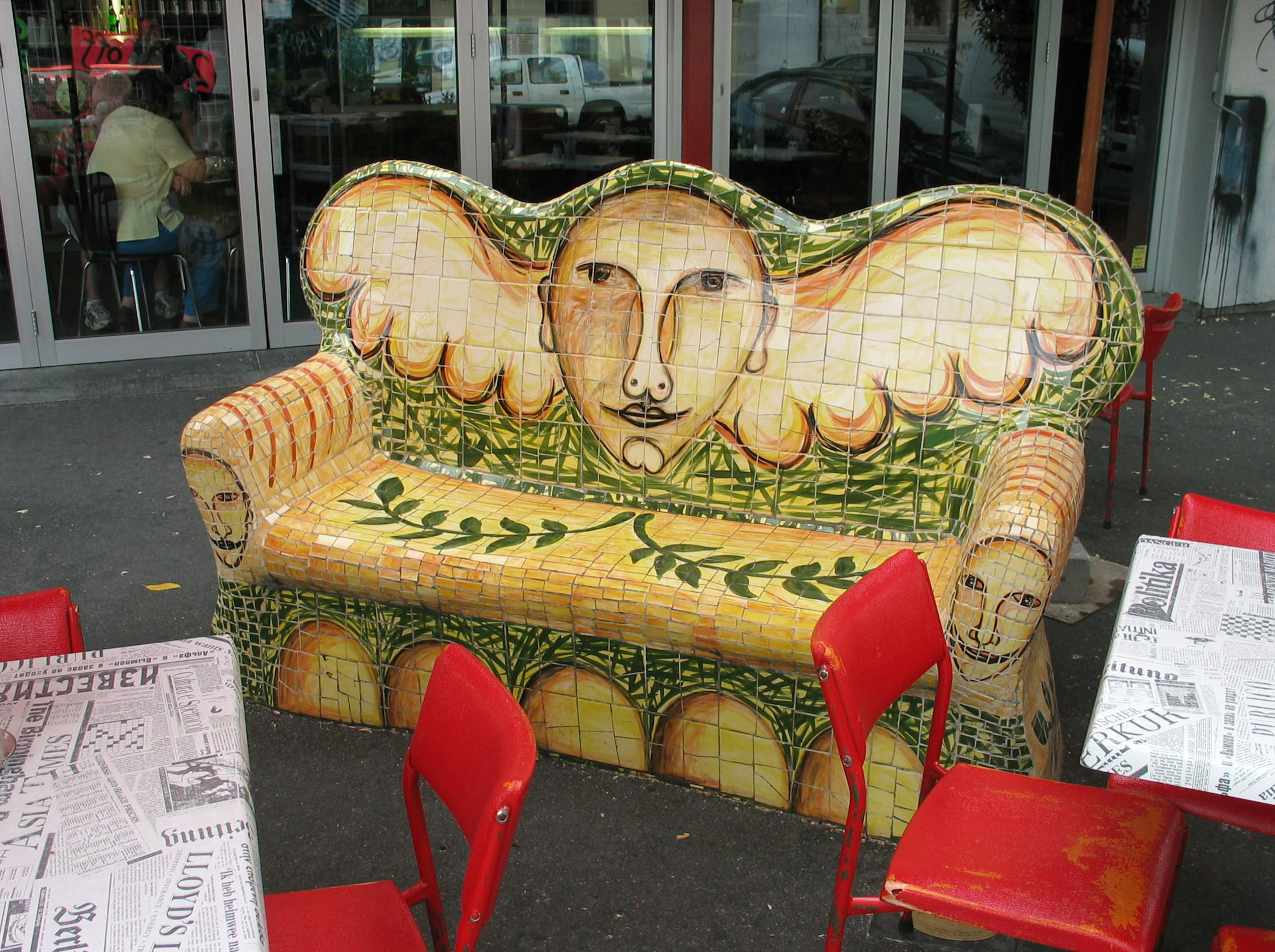 Unique sofa designed with a face and wings decorated with ceramic tiles