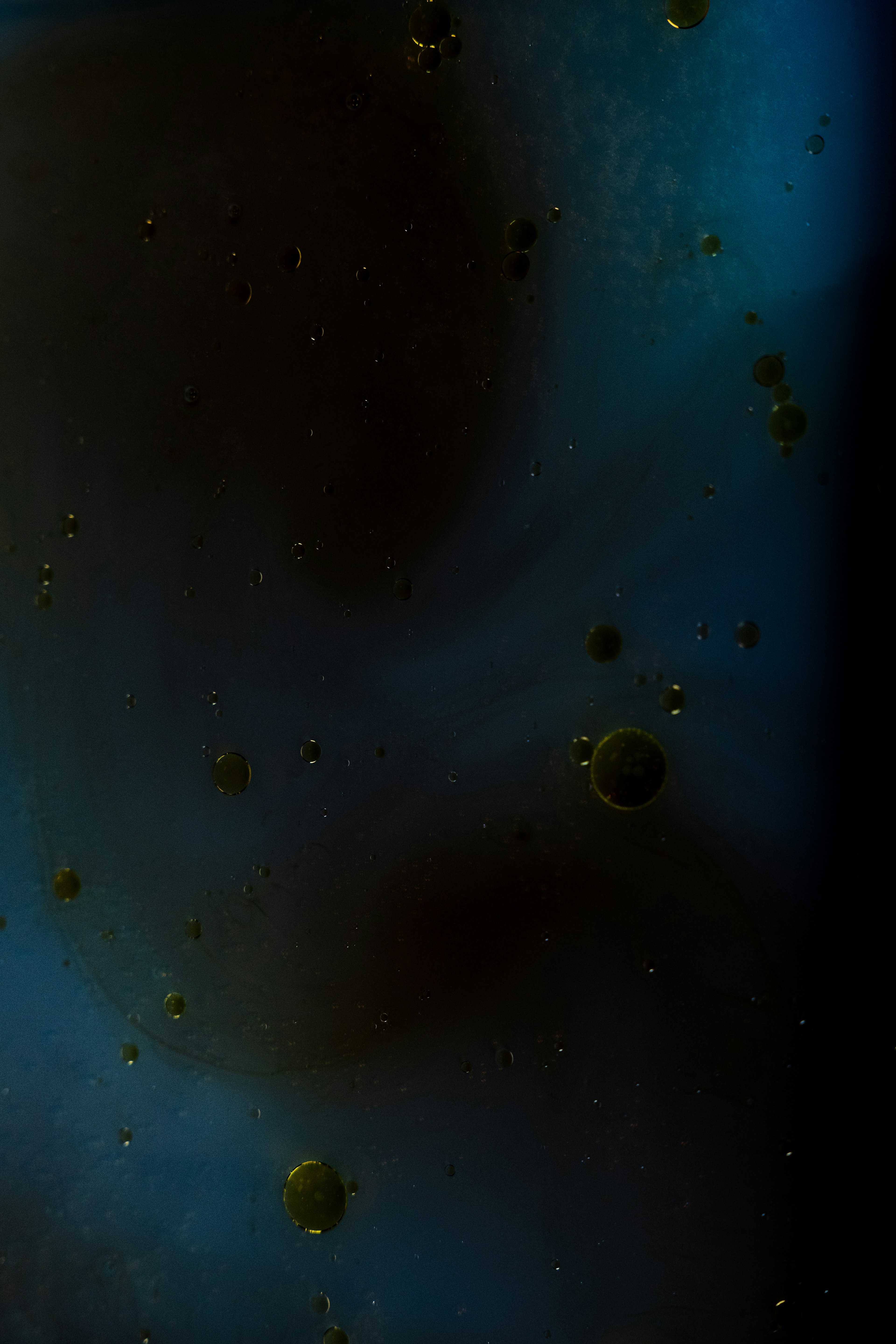 Abstract image with small spheres floating in a blue and black background