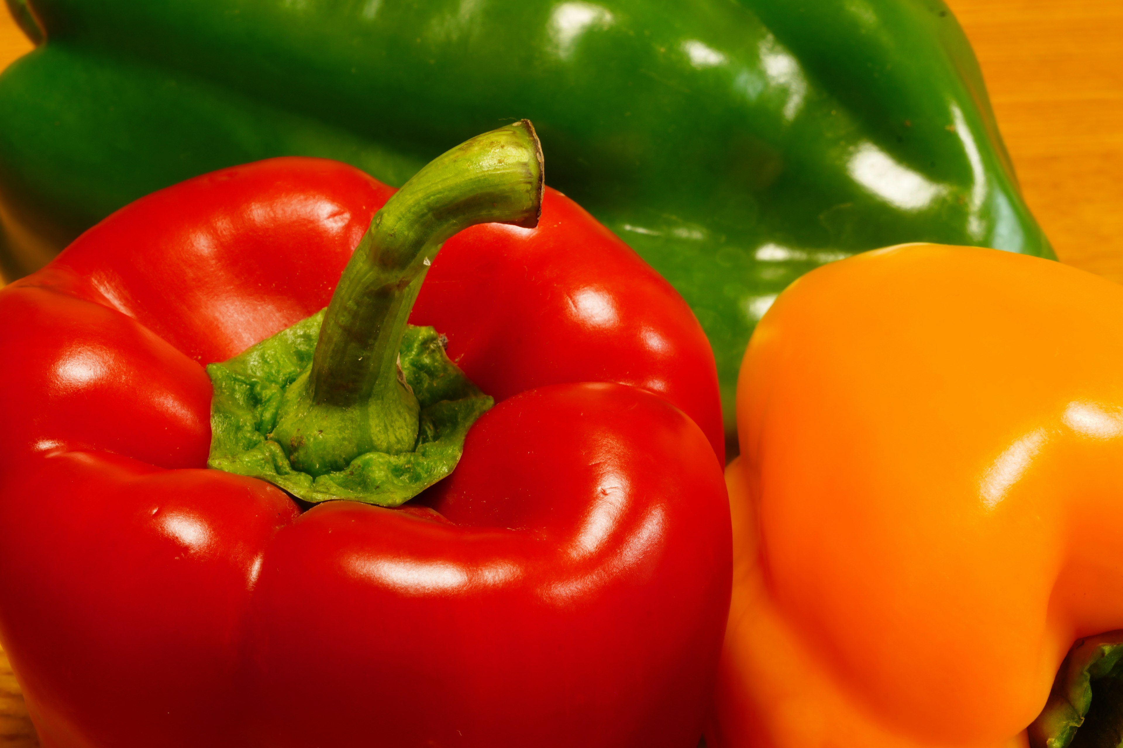 A vibrant display of red, yellow, and green bell peppers