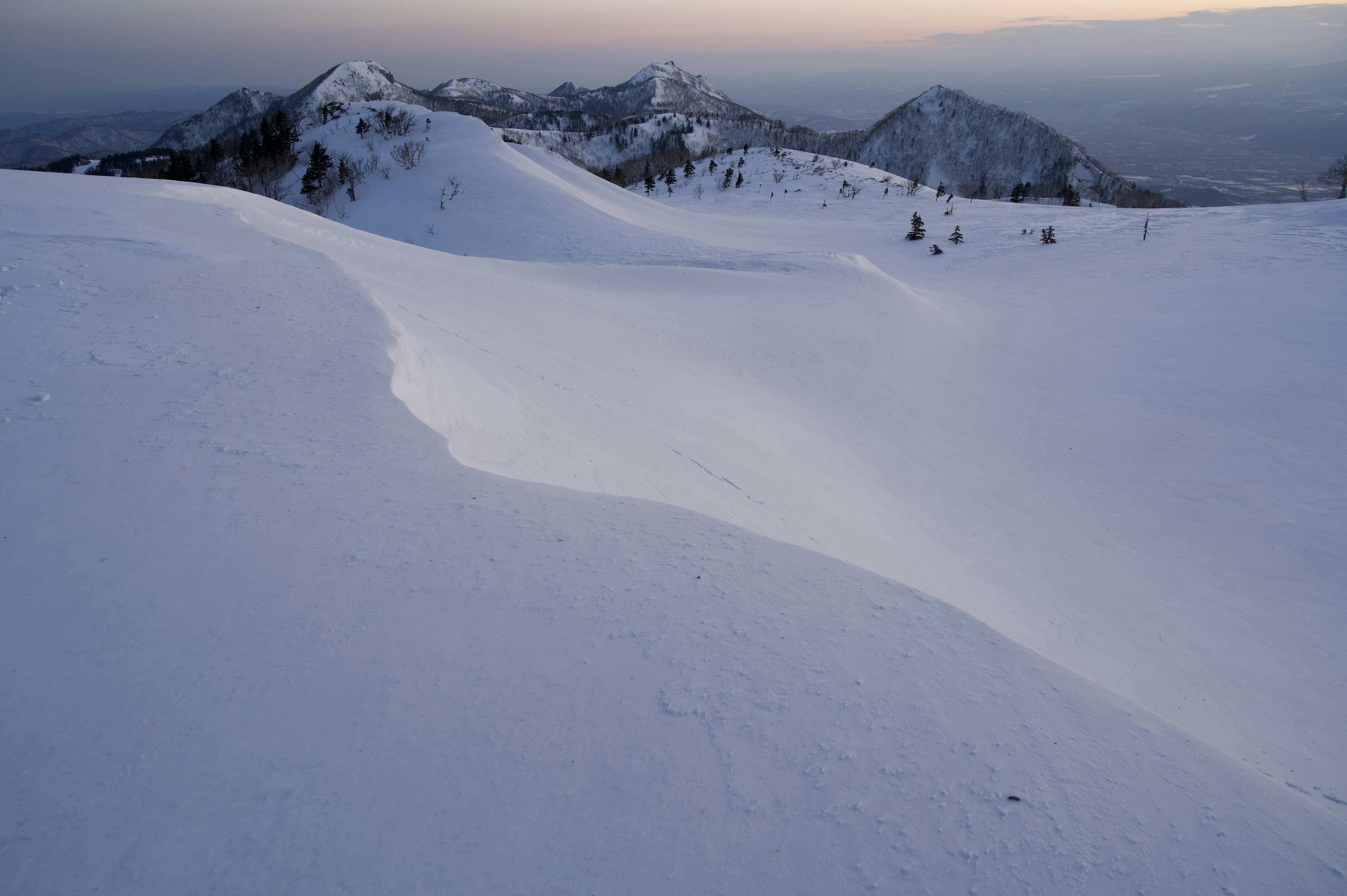 Snow-covered mountain landscape with soft evening light