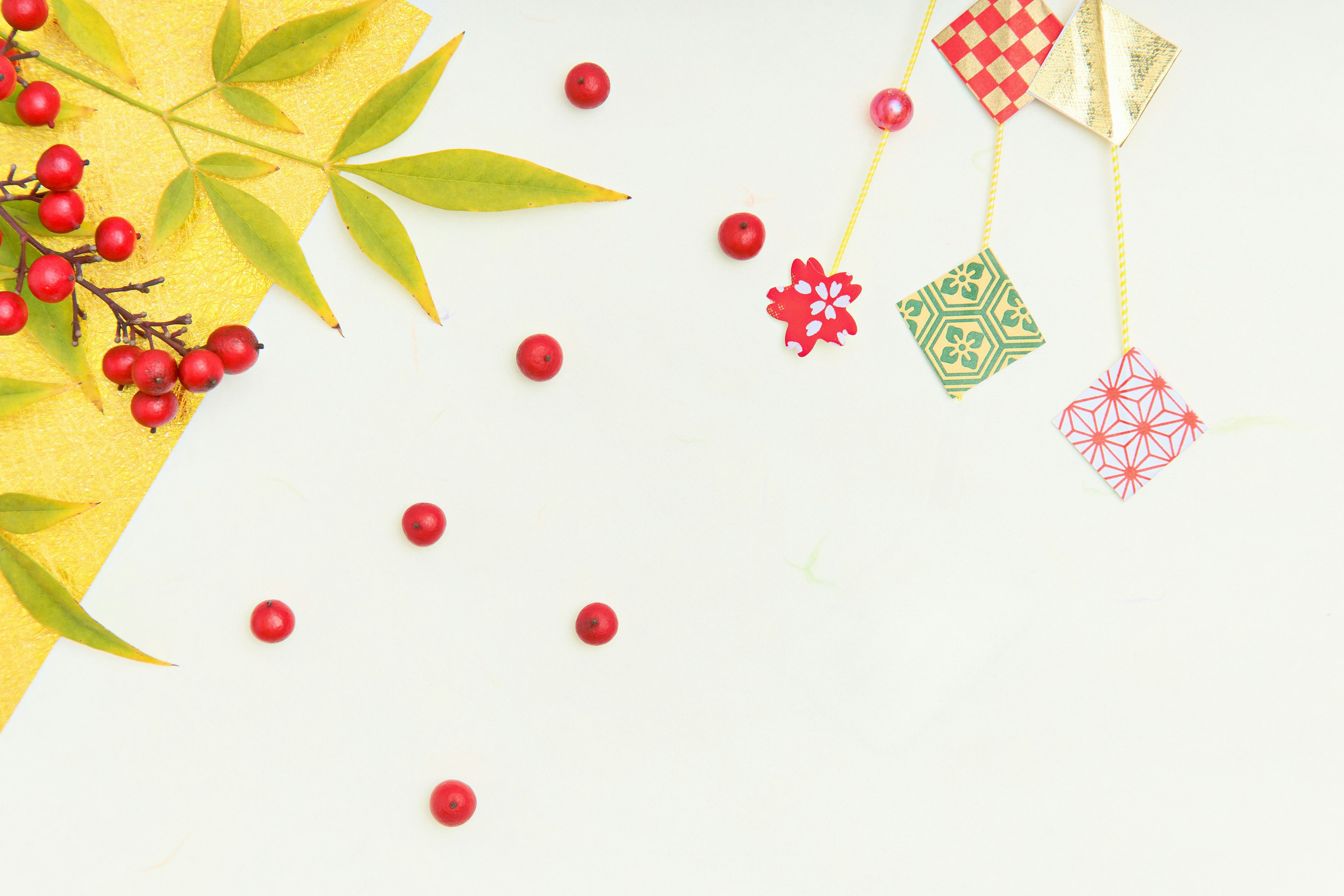 A background with green leaves and scattered red berries featuring colorful hanging decorations